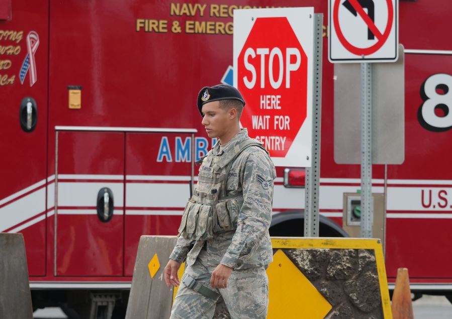 A security guard walks past a naval emergency ambulance responding to a fatal shooting at the Pearl Harbor Naval Shipyard, in Honolulu, Hawaii on December 4, 2019. (Credit: RONEN ZILBERMAN/AFP via Getty Images)