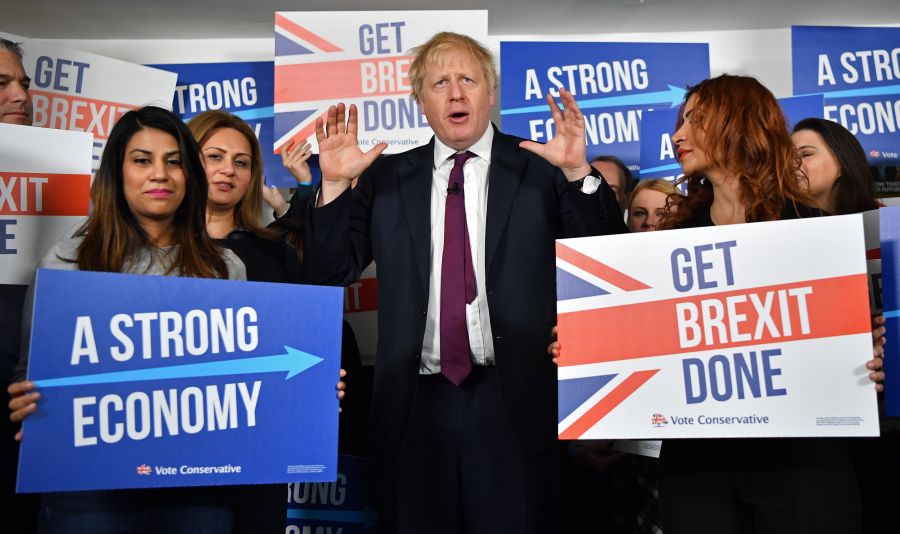 Britain's Prime Minister Boris Johnson speaks to activists and supporters as he poses for a photograph at the Conservative Campaign Headquarters Call Centre in central London on Dec. 8, 2019. (Credit: BEN STANSALL/POOL/AFP via Getty Images)