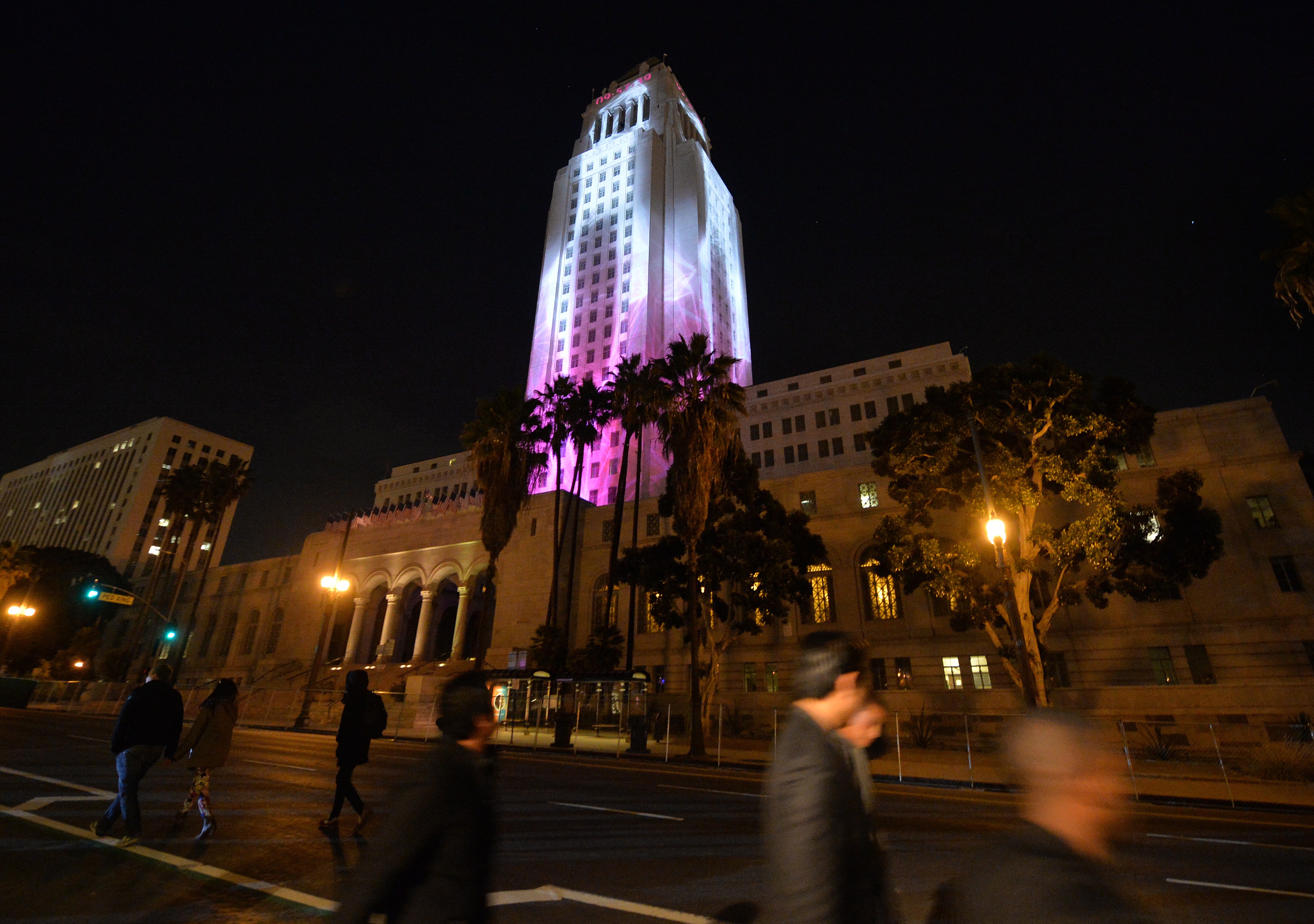 City Hall is lit by two dimensional projected images while people celebrate the New Year at the Grand Park's N.Y.E.L.A. event in downtown Los Angeles on December 31, 2014. (Credit: MARK RALSTON/AFP via Getty Images)