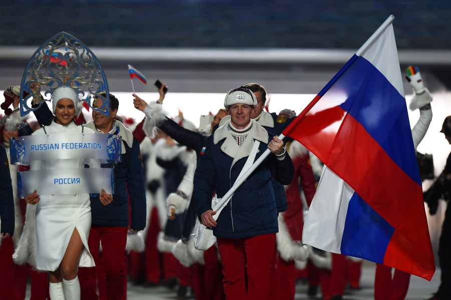 Bobsleigh racer Alexander Zubkov of the Russia Olympic team carries his country's flag alongside model Irina Shayk (left) during the Opening Ceremony of the Sochi 2014 Winter Olympics at Fisht Olympic Stadium on February 7, 2014 in Sochi, Russia. (Credit: Pascal Le Segretain/Getty Images)