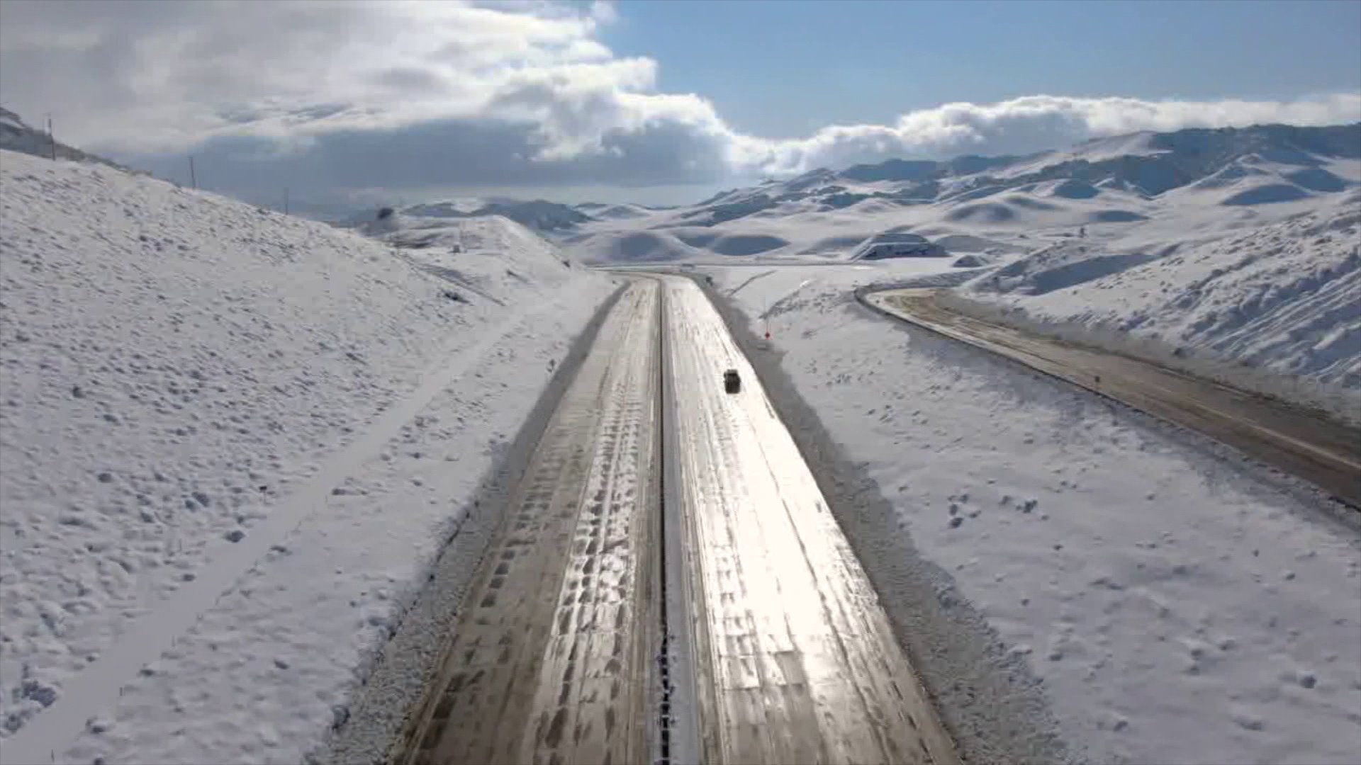 A single vehicle travels on the closed 5 Freeway through the Grapevine on Dec. 27, 2019. (Credit: KTLA)