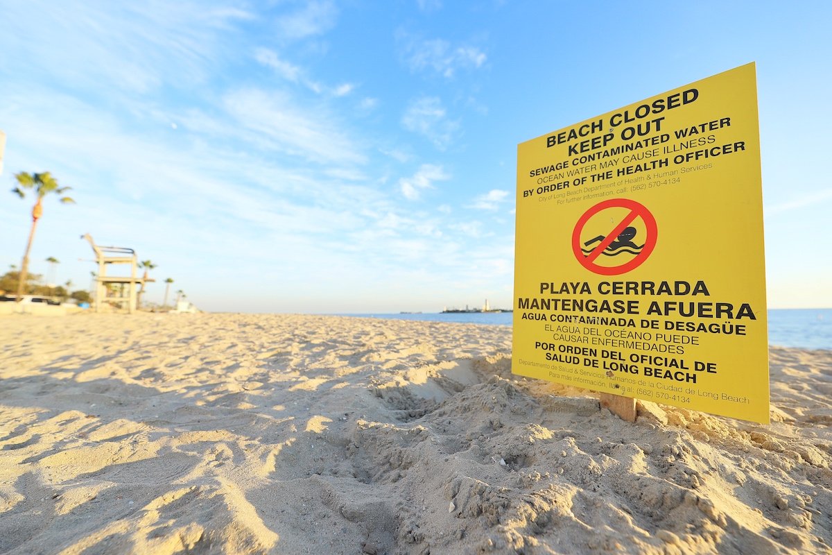 A sign warning swimmers of contaminated water is seen in Long Beach in a photo posted by the City of Long Beach on Jan. 13, 2020.