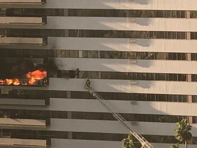 LAFD tweeted this image of a firefighter working to a rescue someone hanging outside Barrington Plaza amid a fire on Jan. 29, 2020.