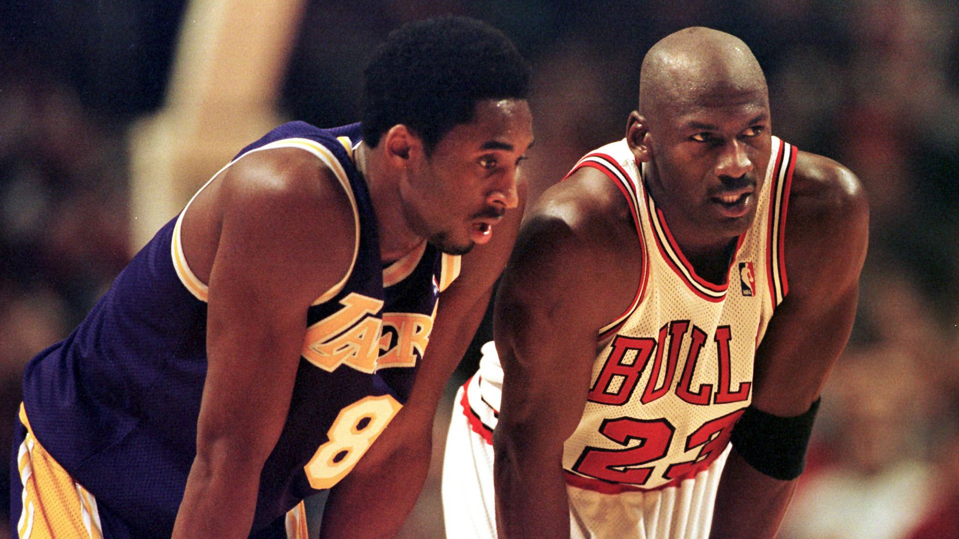 Kobe Bryant and Michael Jordan talk during a game at the United Center in Chicago on Dec. 17, 1997. (Credit: Vincent Laforet/AFP via Getty Images)