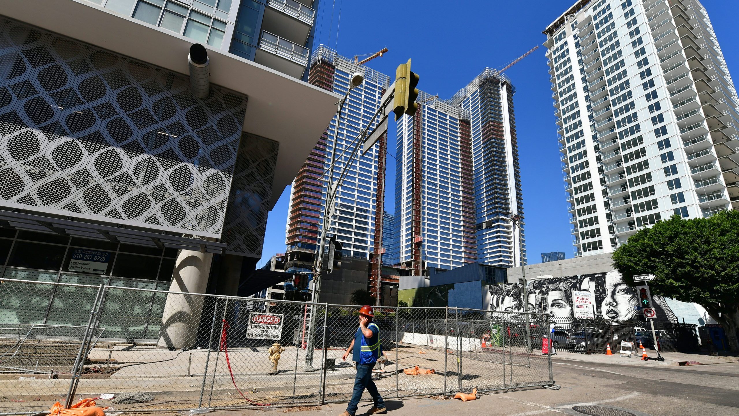 A worker walks amid luxury high-rise apartments under construction in Los Angeles on Oct. 8, 2019. (Credit: Frederic J. Brown / AFP / Getty Images)