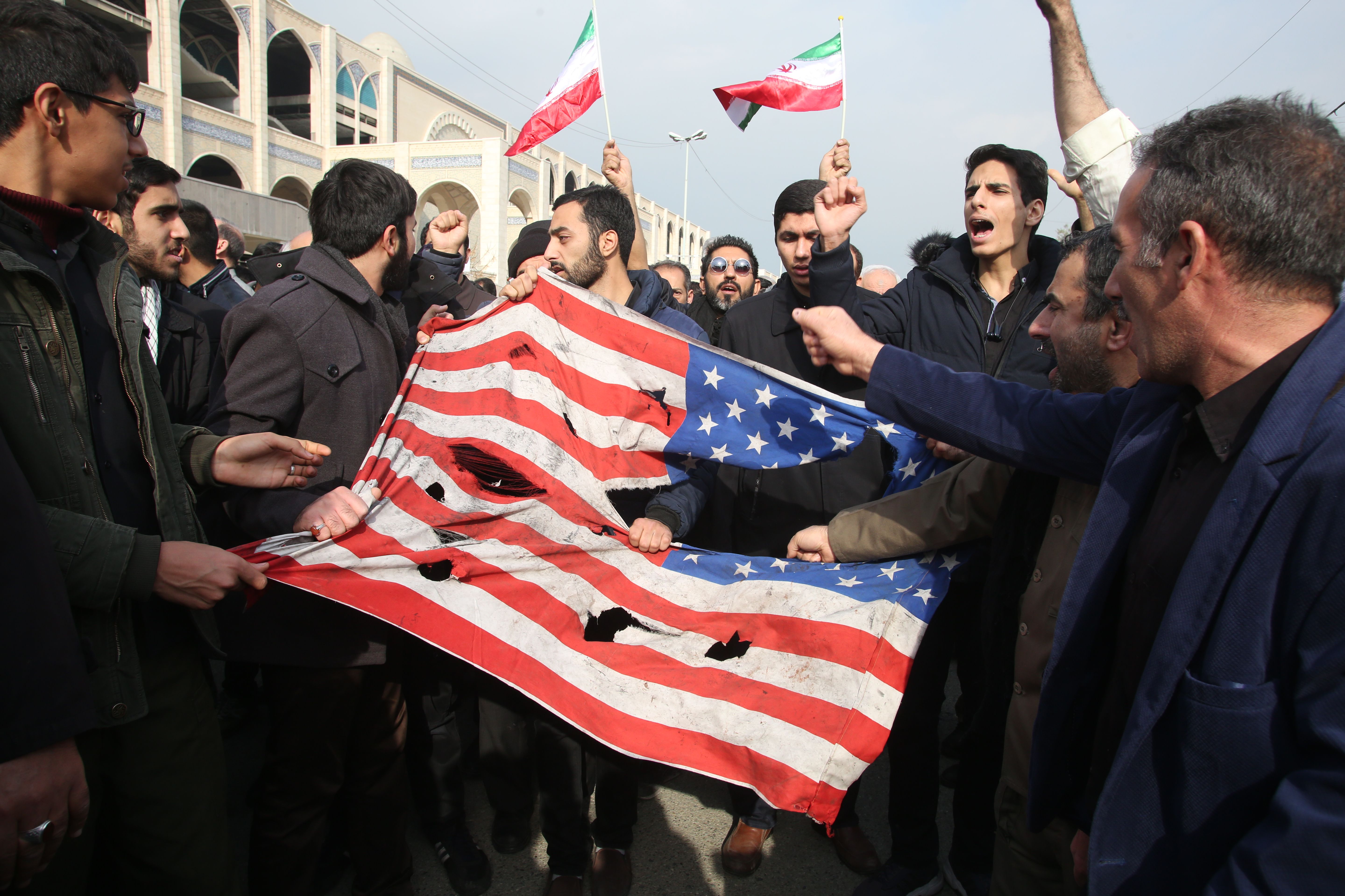 Iranians tear up a U.S. flag during a demonstration in Tehran on Jan. 3, 2020, following the killing of Iranian Revolutionary Guards Major General Qasem Soleimani in a U.S. strike on his convoy at Baghdad international airport. (Credit: Atta Kenare/AFP via Getty Images)