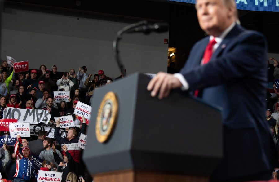 Protesters hold signs as U.S. President Donald Trump holds a "Keep America Great" campaign rally at Huntington Center in Toledo, Ohio, on Jan. 9, 2020. (Credit: Saul Loeb / AFP via Getty Images)