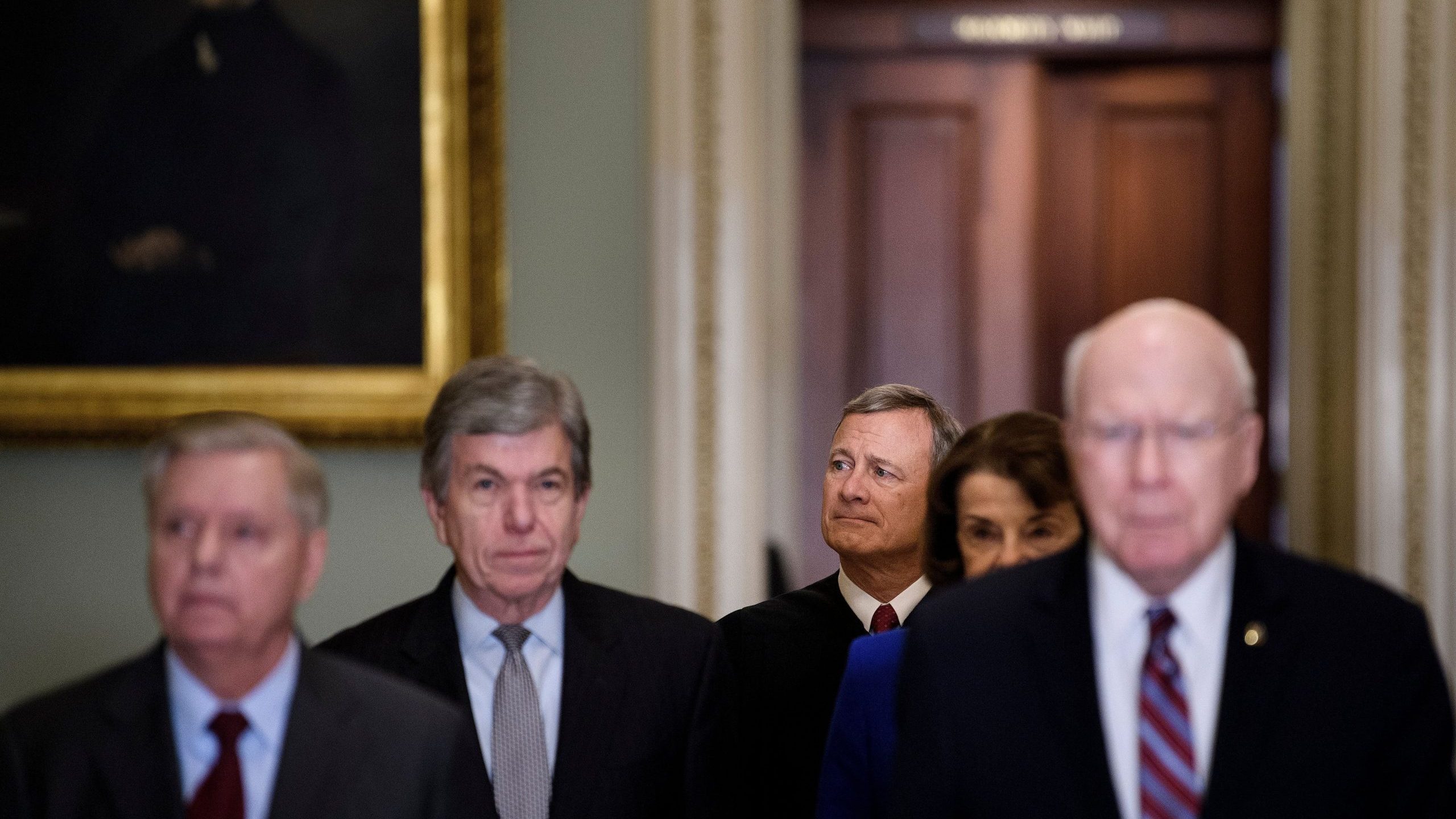 Supreme Court Justice John Roberts (center rear) is escorted to the US Senate Chamber by Senators Lindsey Graham (left), Roy Blunt (2nd left) and Patrick Leahy at the U.S. Capitol in Washington, D.C., on Jan 16, 2020. (Credit: BRENDAN SMIALOWSKI/AFP via Getty Images)