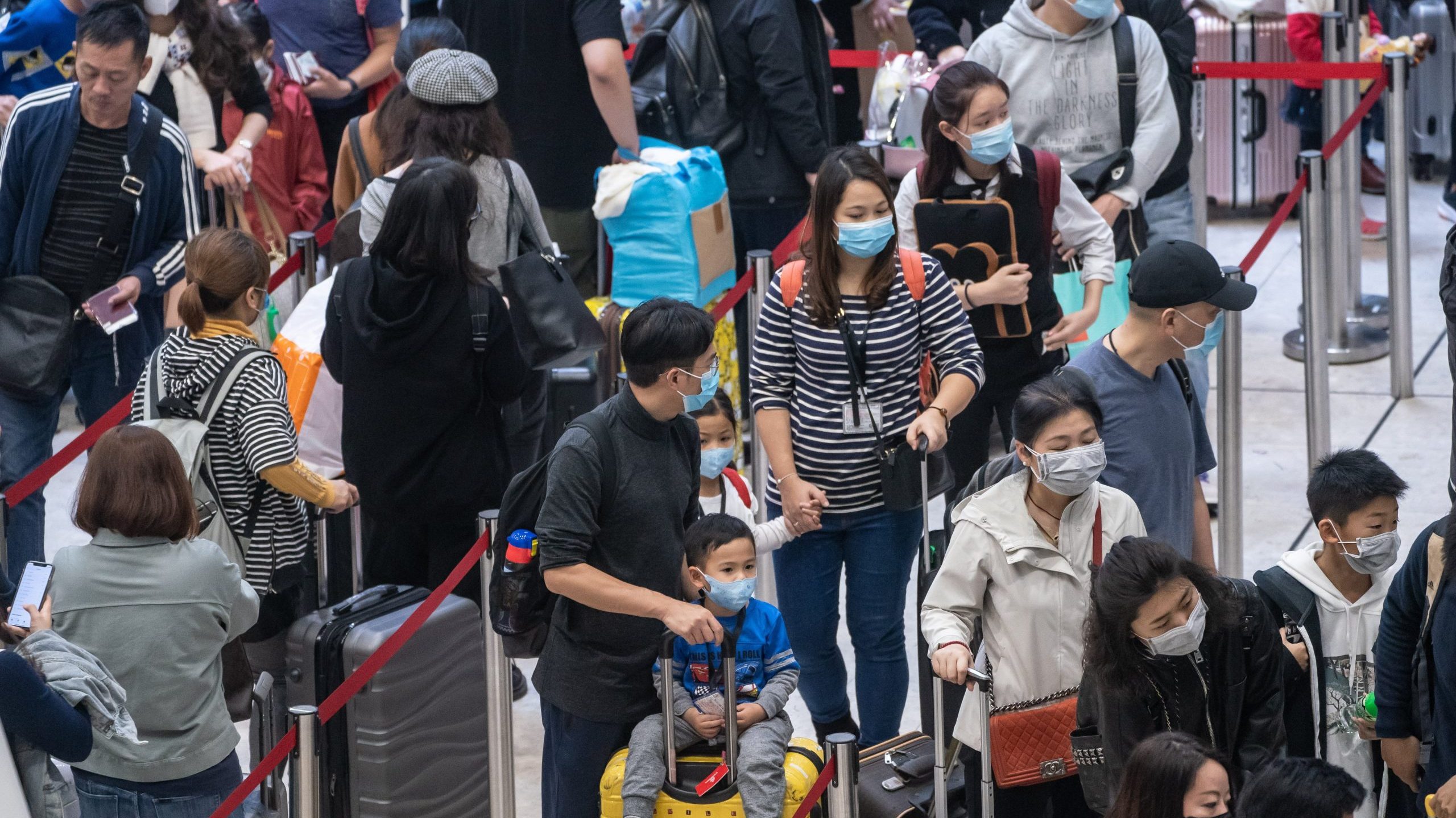 Travelers wearing face masks wait in line at the departure hall of West Kowloon Station on Jan. 23, 2020 in Hong Kong. (Credit: Anthony Kwan/Getty Images)