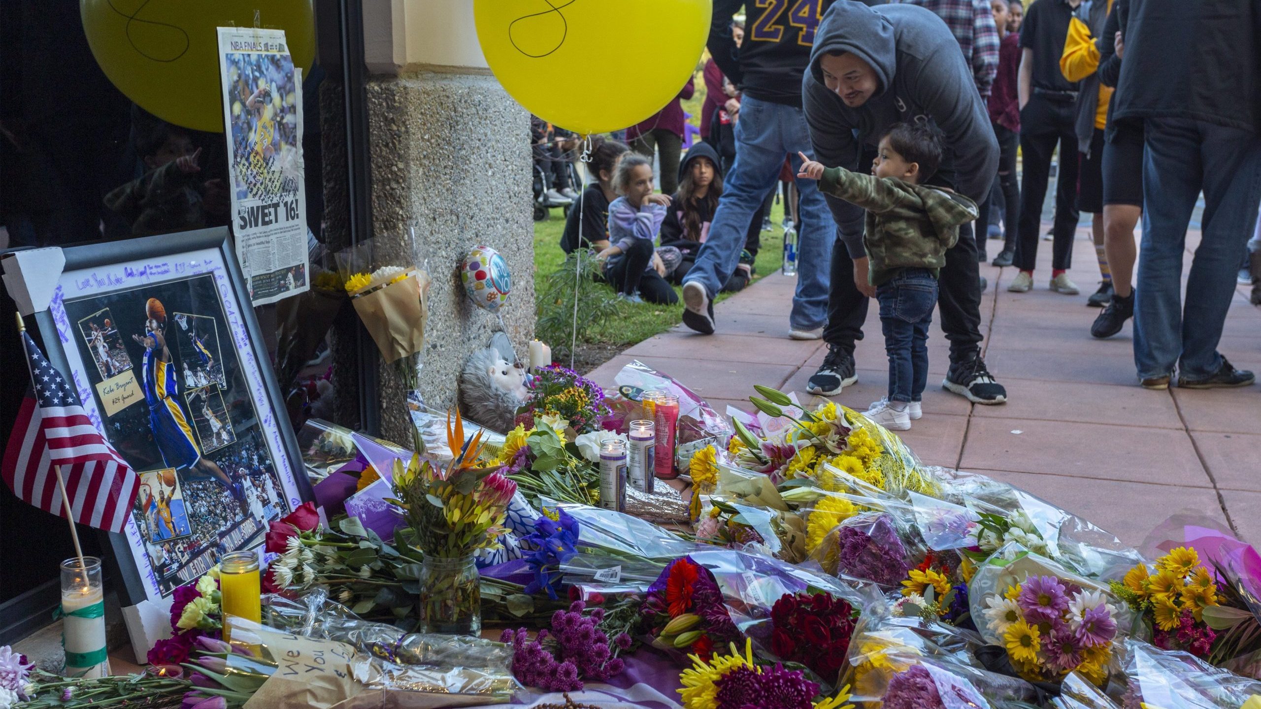 People mourn at a makeshift memorial at Mamba Sports Academy for former NBA great Kobe Bryant, who was killed in a helicopter crash while commuting to the academy on Jan. 26, 2020 in Newbury Park. (Credit: David McNew/Getty Images)