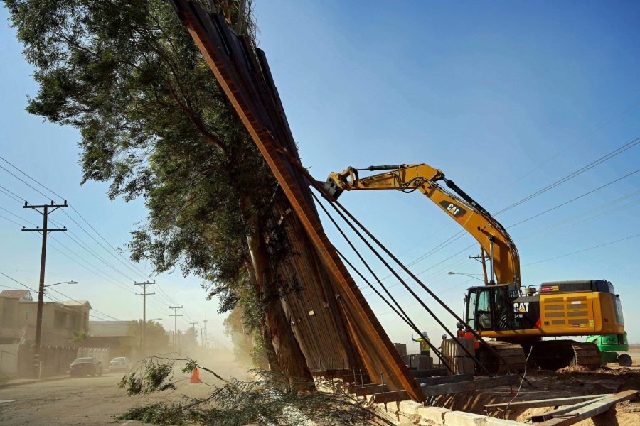 A construction crew works on a fallen section of the U.S.-Mexico border wall as seen from Mexico on Jan. 29, 2020. (Credit: STR/AFP via Getty Images)