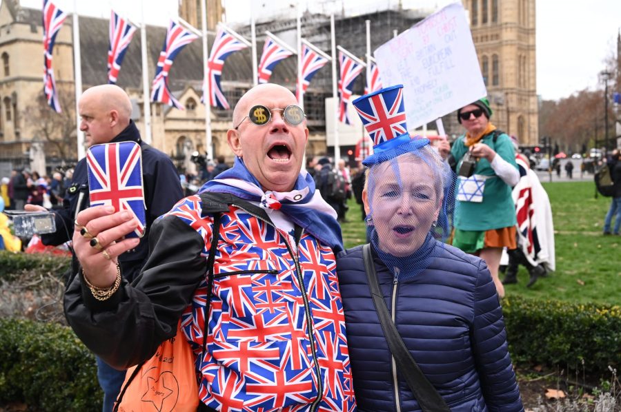 Brexit supporters wearing Union Flag-themed dress react in Parliament Square in London on Jan. 31, 2020, the day the U.K. formally leaves the European Union. (Credit: GLYN KIRK/AFP via Getty Images)