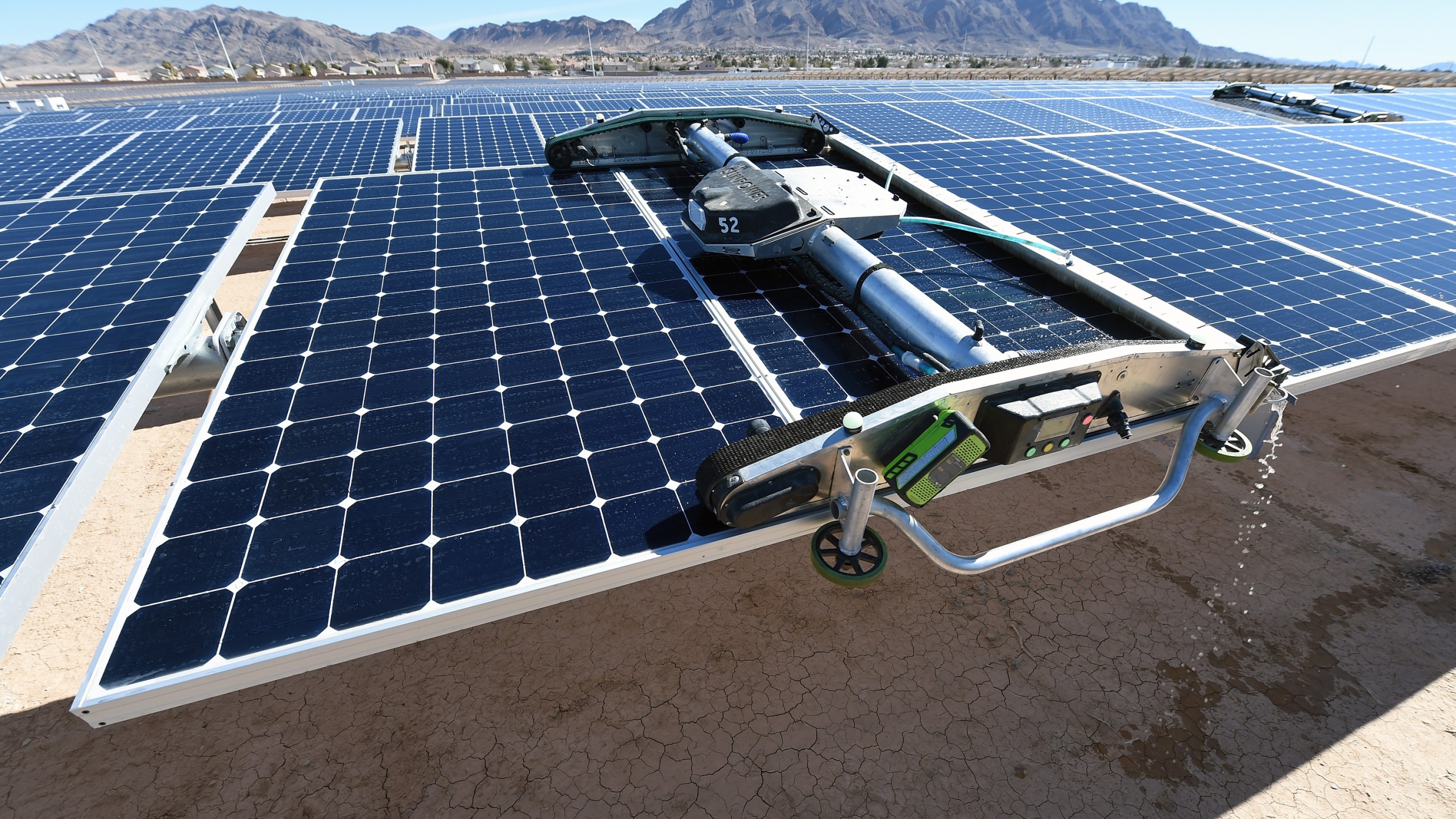 A panel-washing robot cleans a row of solar panels during a dedication ceremony to commemorate the completion of the 102-acre, 15-megawatt Solar Array II Generating Station at Nellis Air Force Base on Feb. 16, 2016, in Las Vegas, Nevada. (Ethan Miller/Getty Images)