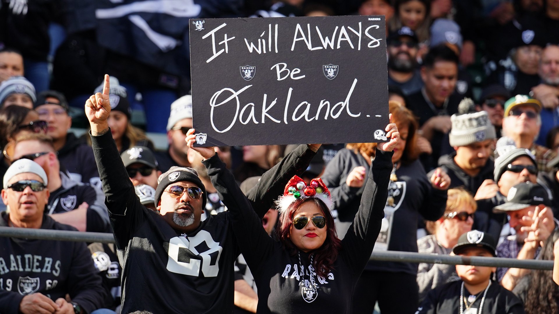 Fans in the stands hold signs during a game between the Oakland Raiders and the Jacksonville Jaguars in Oakland on Dec. 15, 2019. (Credit: Daniel Shirey / Getty Images)