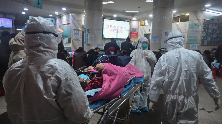 In this photo taken on January 25, 2020, medical staff wearing protective clothing to protect against a previously unknown coronavirus arrive with a patient at the Wuhan Red Cross Hospital in Wuhan. (Credit: Hector Retamal/AFP/Getty Images)