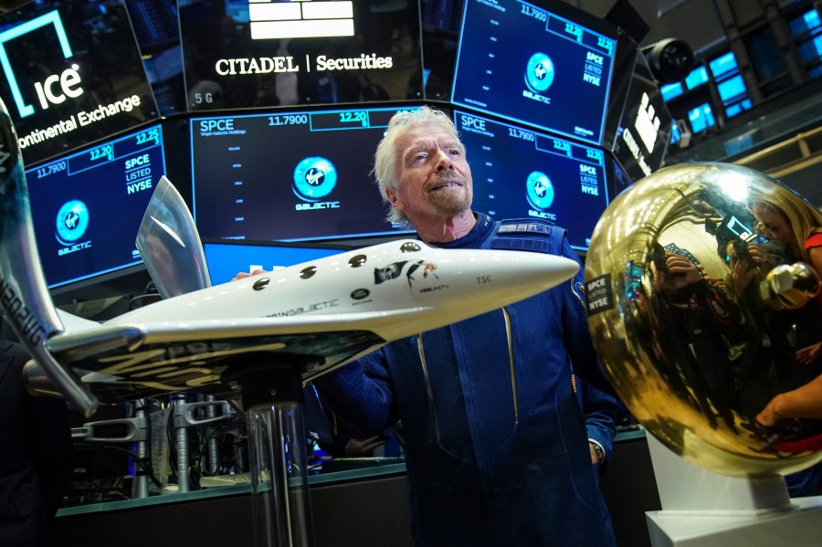 Sir Richard Branson, founder of Virgin Galactic, poses for photographs before ringing a ceremonial bell on the floor of the New York Stock Exchange on the company’s first day of trading shares, Oct. 28, 2019. (Credit: Drew Angerer / Getty Images)