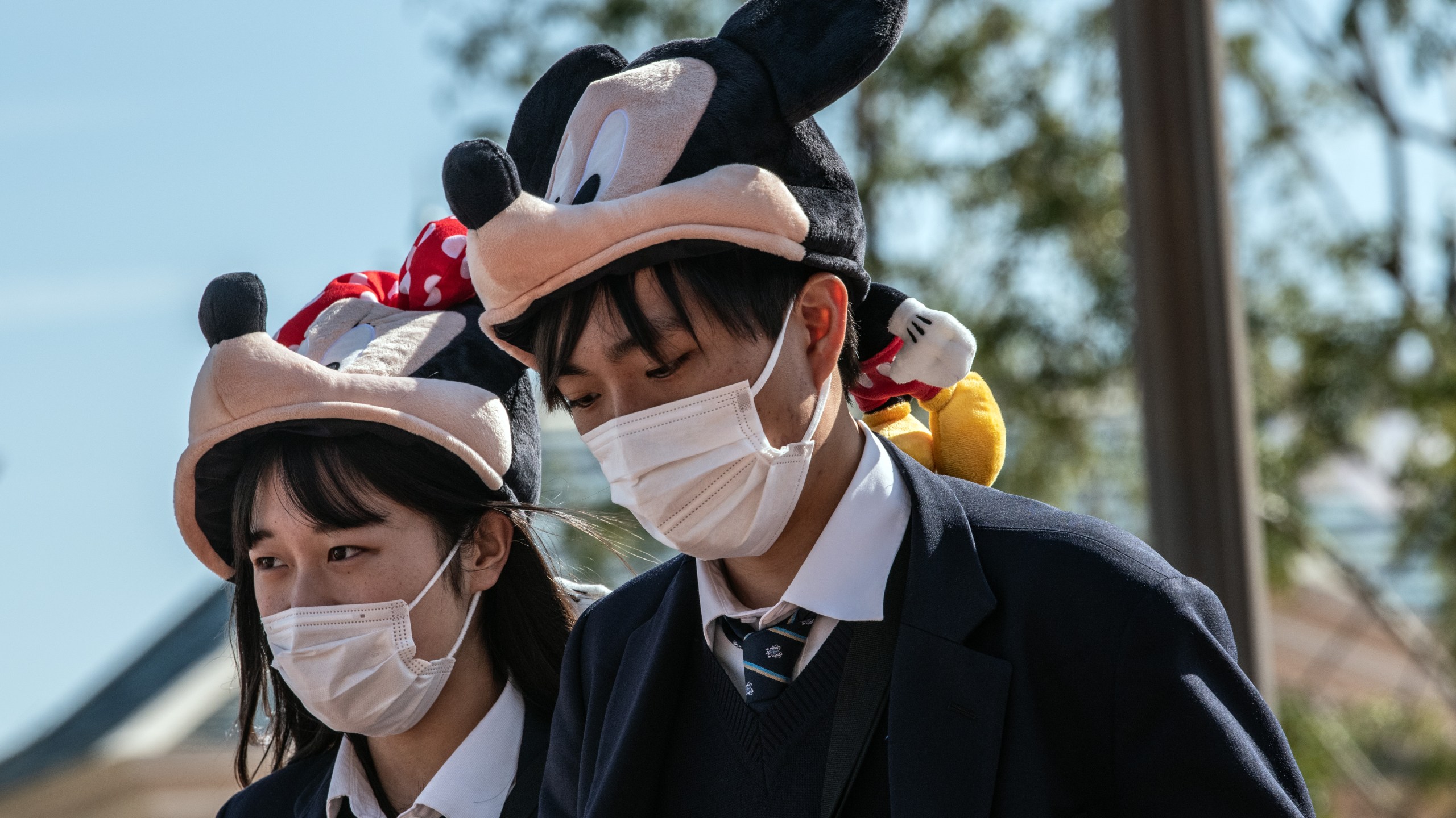 Students wearing Disney character hats and face masks leave Tokyo Disneyland on the day it announced it will close until March 15th because of concerns over the Covid-19 virus, on Feb. 28, 2020. (Carl Court/Getty Images)