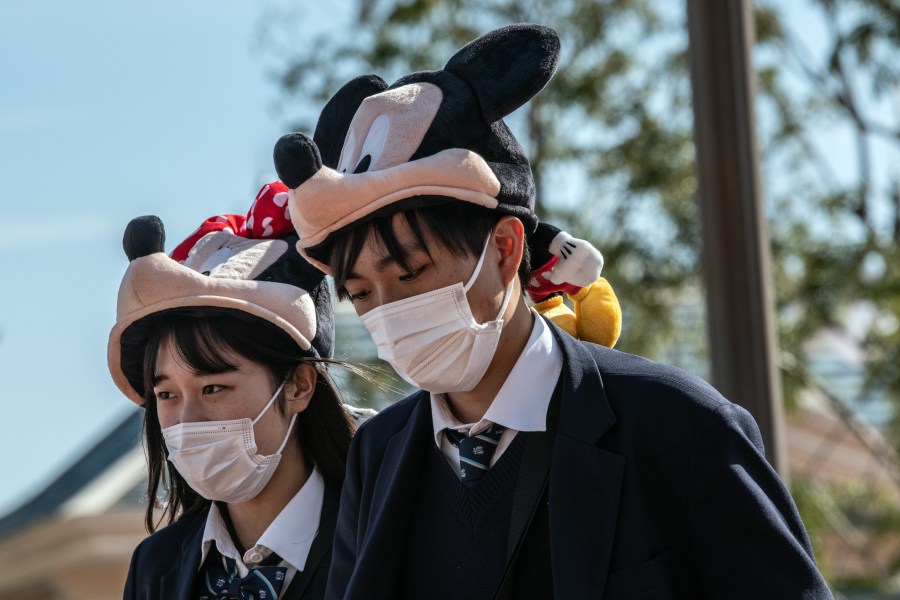 Students wearing Disney character hats and face masks leave Tokyo Disneyland on the day it announced it will close until March 15th because of concerns over the Covid-19 virus, on Feb. 28, 2020. (Carl Court/Getty Images)