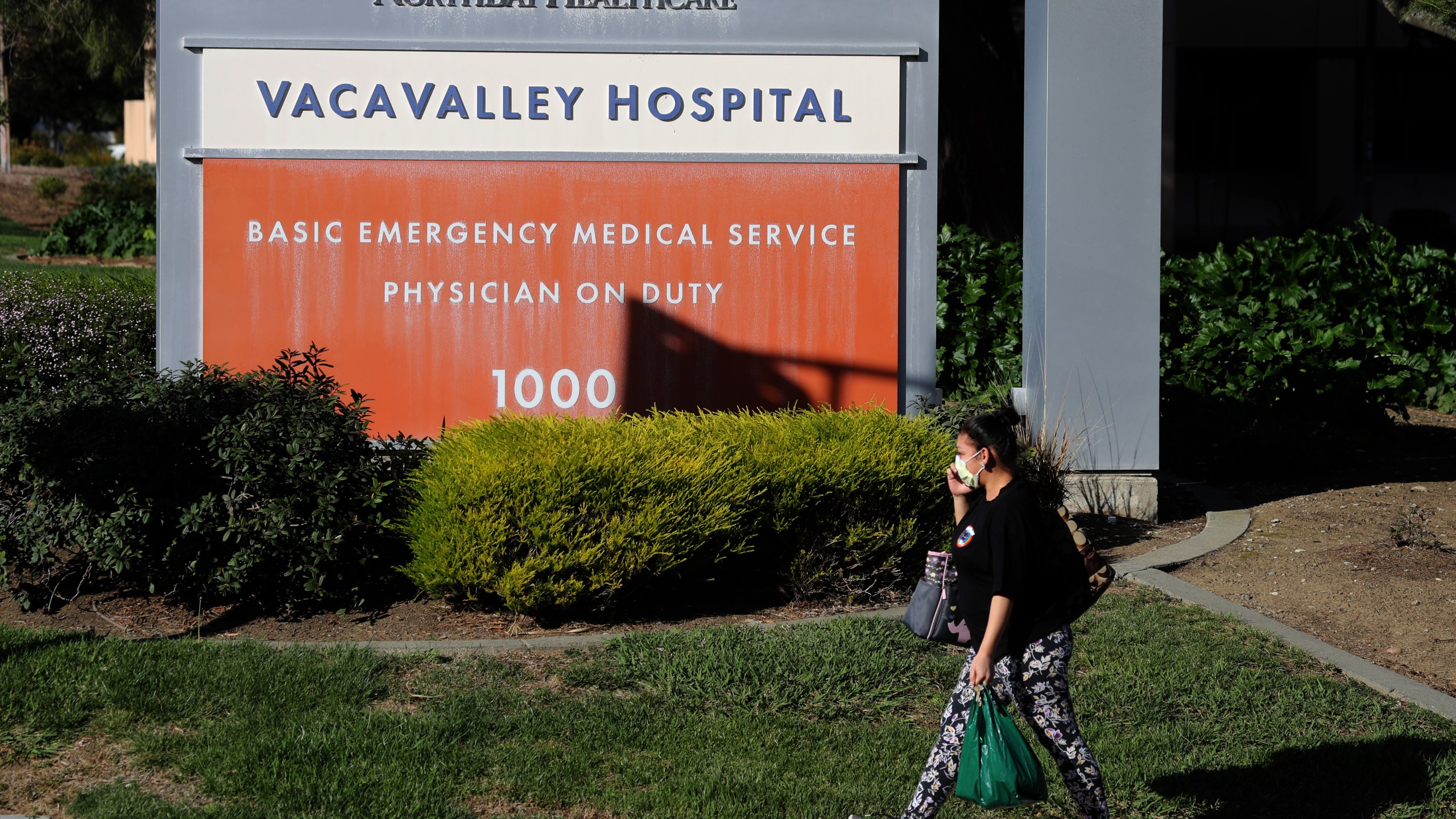 A pedestrian wears a surgical mask as she walks by the VacaValley Hospital on Feb. 27, 2020 in Vacaville. (Credit: Justin Sullivan/Getty Images)