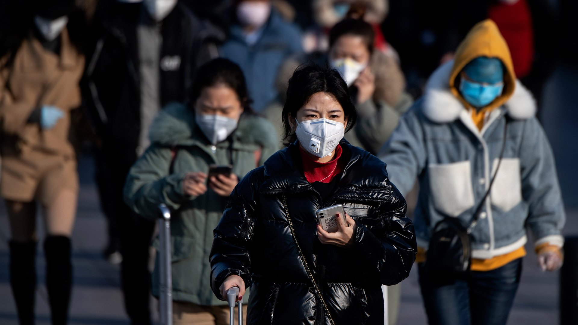 Travelers wearing face masks arrive from various provinces at the Beijing Railway Station on February 3, 2020. (Credit: Noel Celis/AFP/Getty Images)