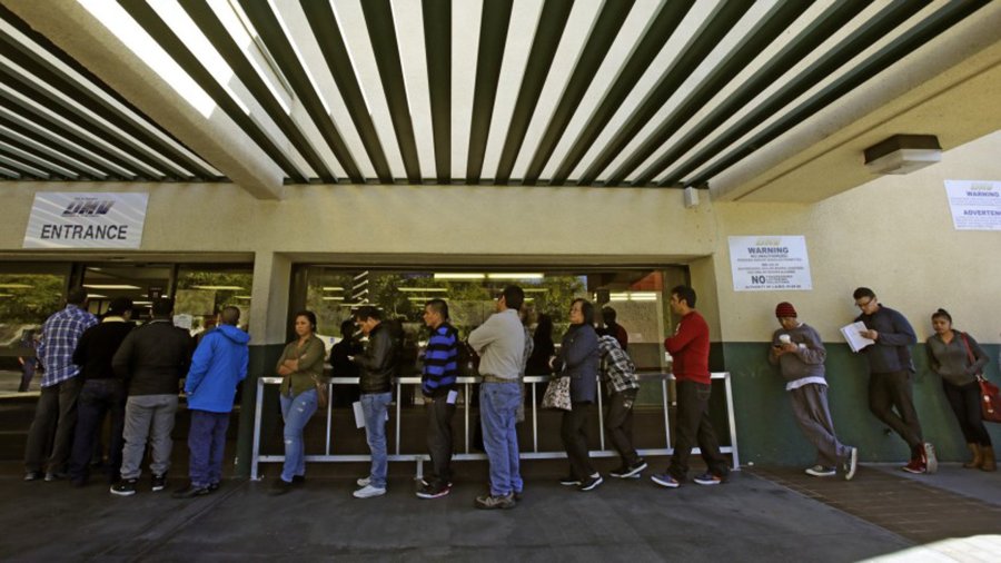 People stand at a DMV office in Los Angeles in 2014. (Credit: Irfan Khan / Los Angeles Times)