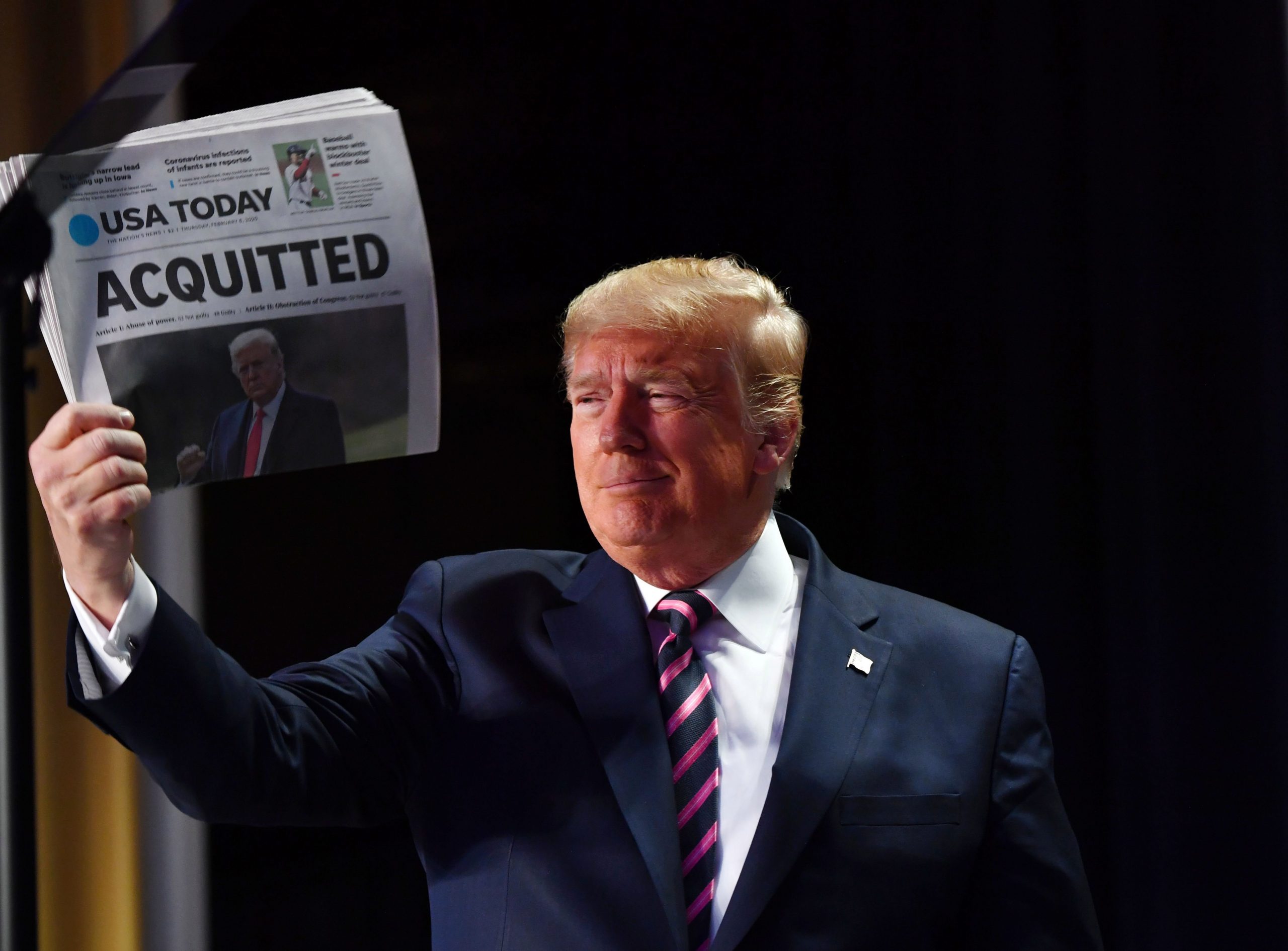 President Donald Trump holds up a newspaper with the headline that reads "ACQUITTED" at the 68th annual National Prayer Breakfast, at the Washington Hilton on Feb. 6, 2020, in Washington.(Credit: NICHOLAS KAMM/AFP via Getty Images)