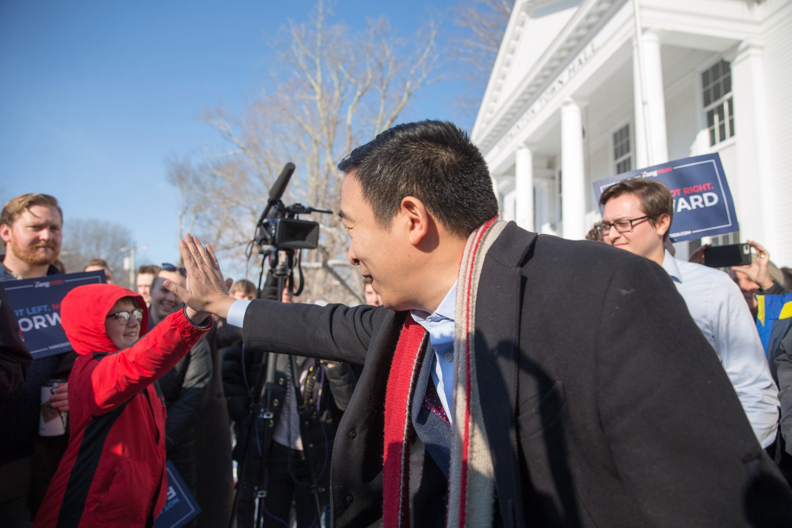 Democratic presidential candidate Andrew Yang high-fives a boy outside of Hopkinton Town Hall following a campaign event on Feb. 9, 2020, in New Hampshire. (Credit: Scott Eisen/Getty Images)