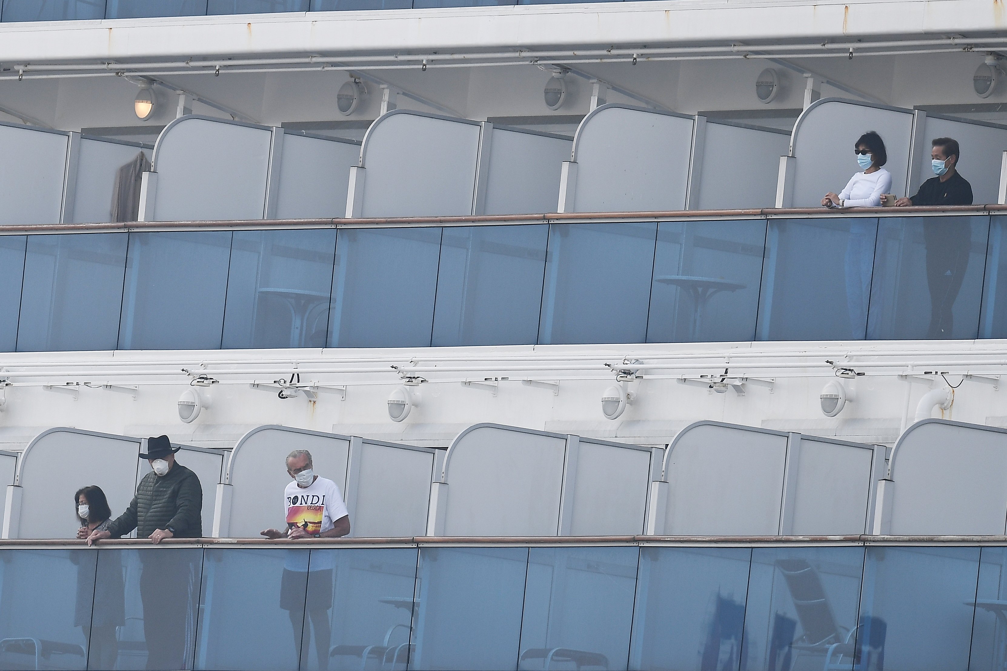 Passengers walk along the deck of the Diamond Princess cruise ship, with around 3,600 people quarantined onboard due to fears of the new COVID-19 coronavirus, at the Daikoku Pier Cruise Terminal in Yokohama on Feb. 14, 2020. (Credit: CHARLY TRIBALLEAU/AFP via Getty Images)