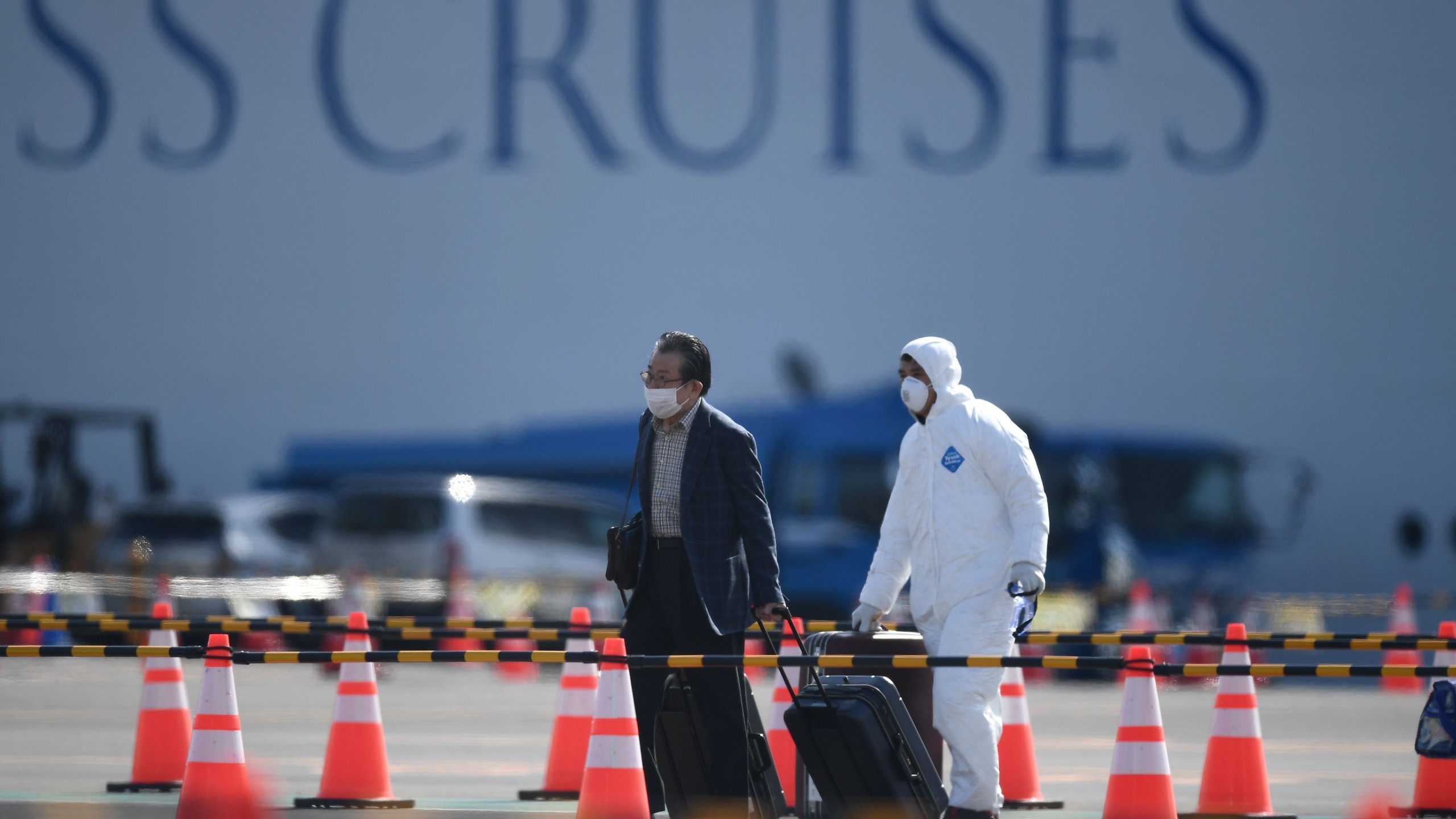 A passenger disembarks from the Diamond Princess cruise ship at the Daikoku Pier Cruise Terminal in Yokohama on Feb. 19, 2020. (Credit: CHARLY TRIBALLEAU/AFP via Getty Images)