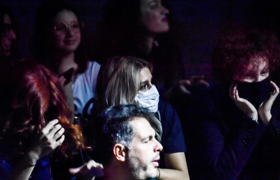 A guest wearing a respiratory mask waits for the start of the Dolce & Gabbana's Women Fall - Winter 2020 fashion collection on Feb. 23, 2020 in Milan. (Credit: ANDREAS SOLARO/AFP via Getty Images)