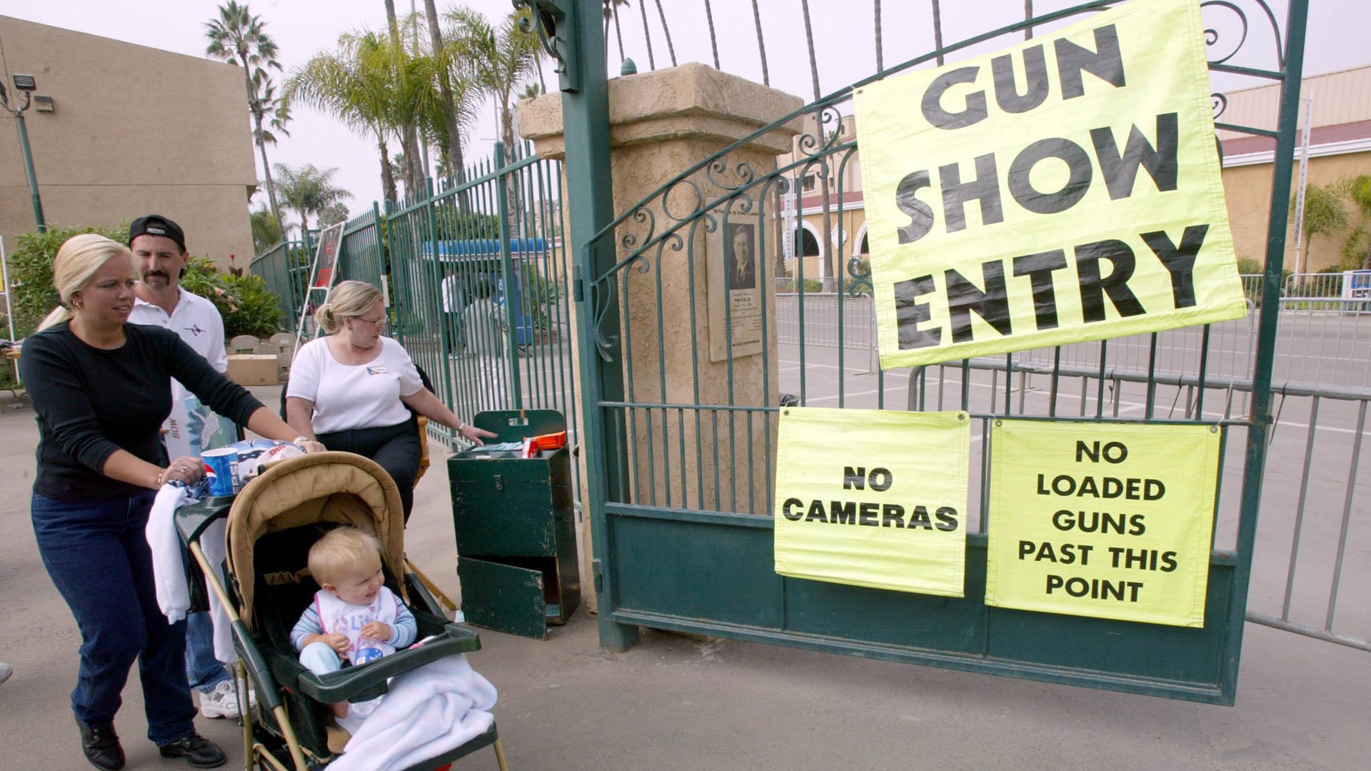 A woman and her child leave the Cross Roads of the West Gun Show in Del Mar on Oct. 20, 2002. (Credit: Hector Mata/AFP via Getty Images)