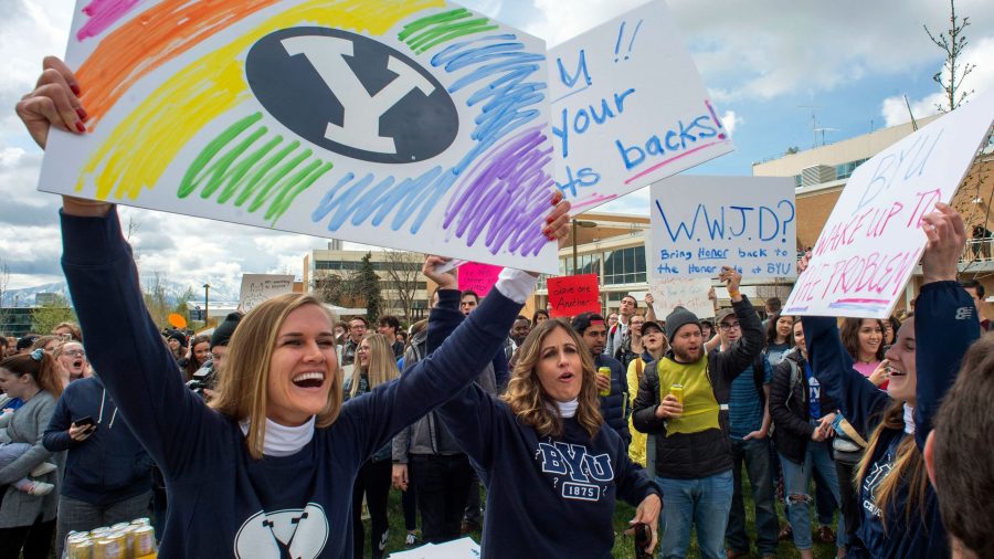 In this April 12, 2019, file photo, Sidney Draughon holds a sign as she takes part in a protest in Provo, Utah, against how the Brigham Young University Honor Code Office investigates and disciplines students. (Credit: Rick Egan/The Salt Lake Tribune via AP, File)