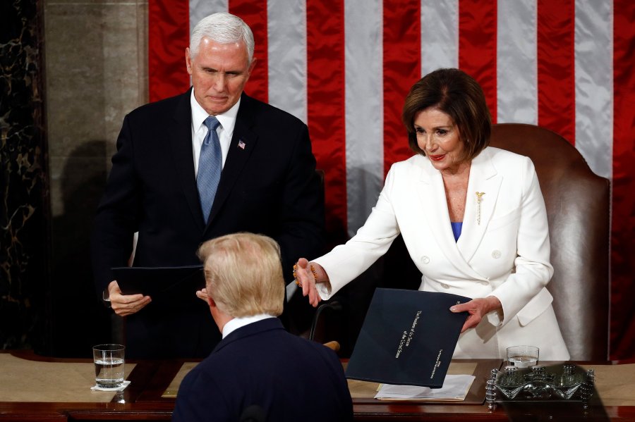 President Donald Trump hands copies of his speech to House Speaker Nancy Pelosi and Vice President Mike Pence as he delivers his State of the Union address on Capitol Hill on Feb. 4, 2020. (Credit: AP Photo/Patrick Semansky via CNN)