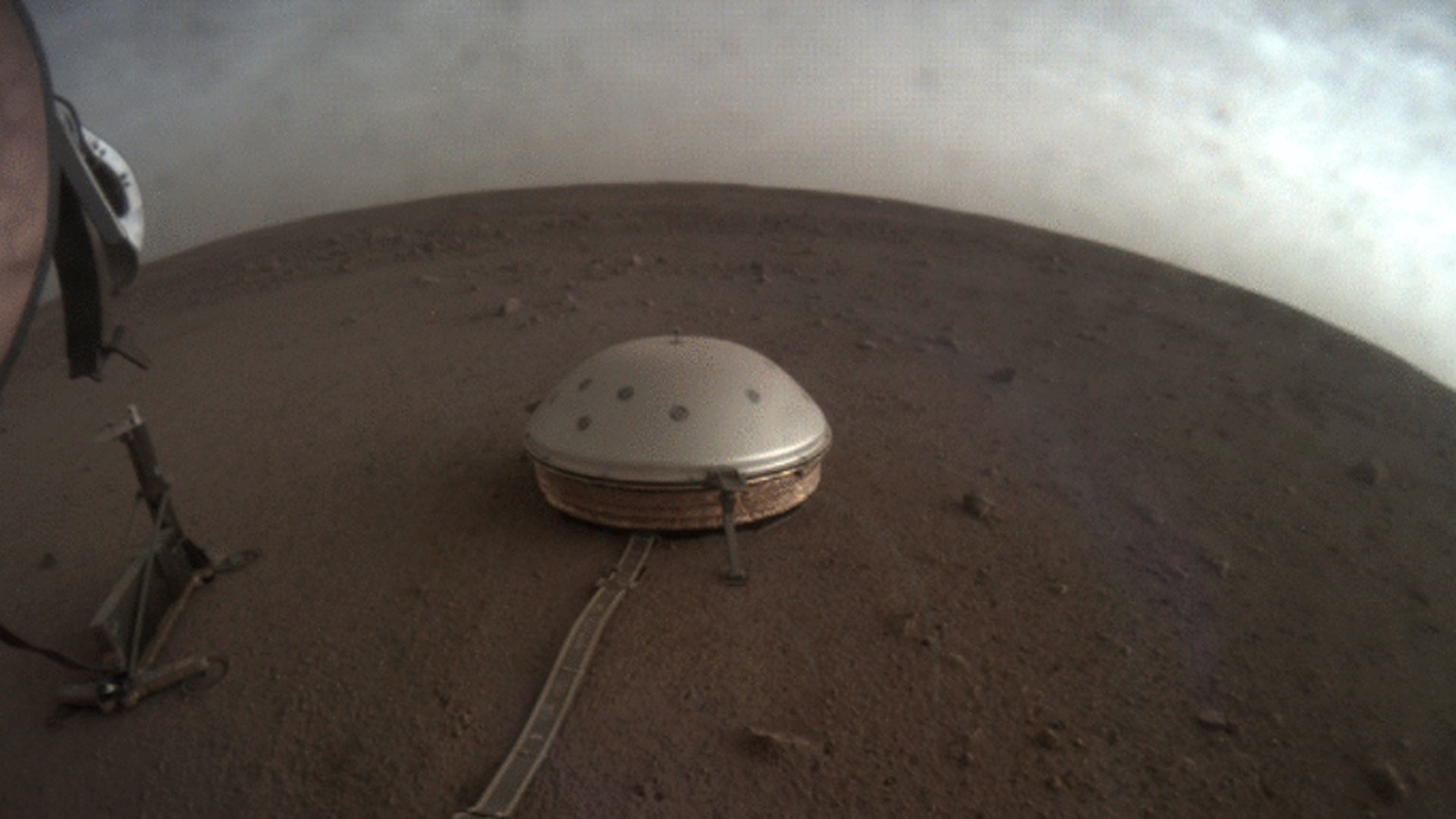 Clouds drift over the dome-covered seismometer, known as SEIS, belonging to NASA's InSight lander, on Mars. (Credit: NASA)