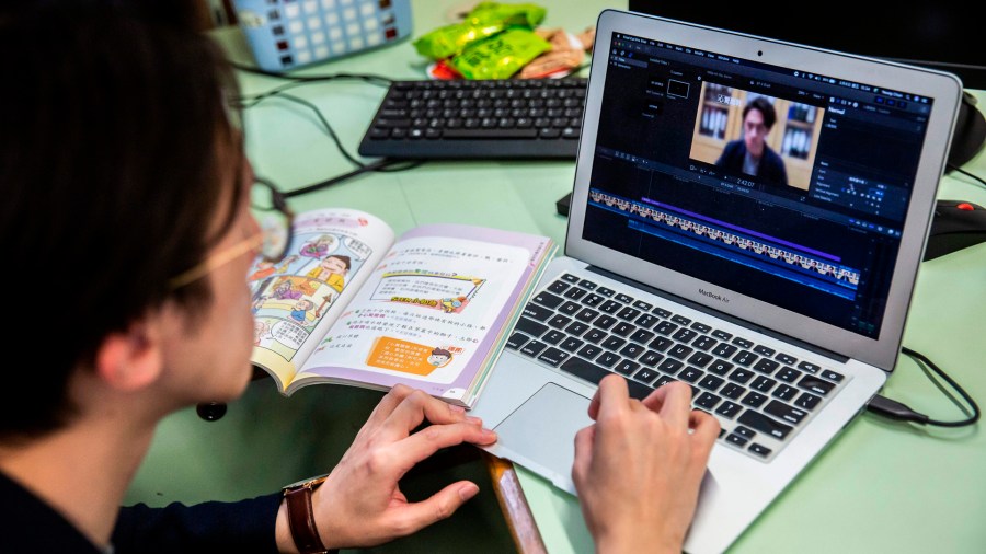 In this photo taken on March 6, 2020, primary school teacher Billy Yeung edits a video lesson he recorded in an empty classroom, for his students who have had their classes suspended due to the COVID-19 coronavirus, in Hong Kong. (Isaac Lawrence/AFP/Getty Images)