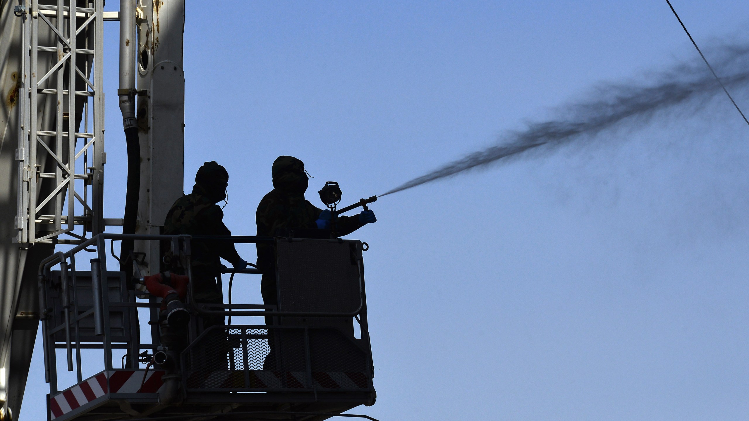 Members of the Iraqi civil defense spray disinfectant on and around a building where Islamic students are quarantined for having had contact with Iraq's first confirmed case of novel coronavirus infection, in the central holy city of Najaf, on Feb. 26, 2020. (Haidar HAMDANI / AFP) (Photo by HAIDAR HAMDANI/AFP via Getty Images)