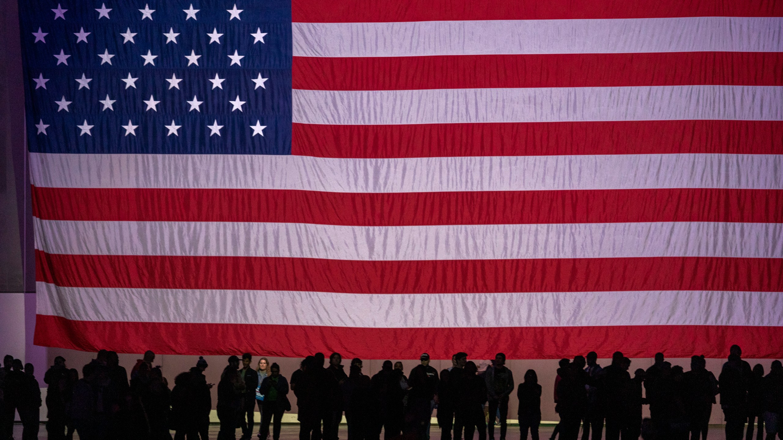 Supporters are dwarfed by an American flag at a campaign rally for Presidential candidate Sen. Bernie Sanders at the Los Angeles Convention Center on March 1, 2020. (David McNew/Getty Images)