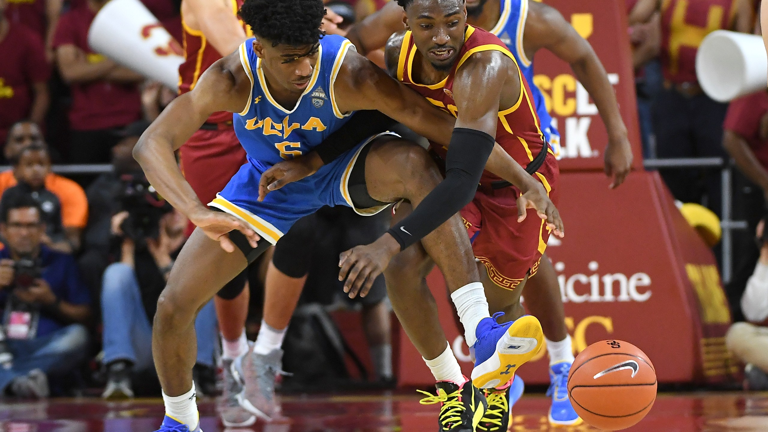 Chris Smith #5 of the UCLA Bruins and Jonah Mathews #2 of the USC Trojans battle for a loose ball in the second half of the game at Galen Center on March 7, 2020. (Jayne Kamin-Oncea/Getty Images)