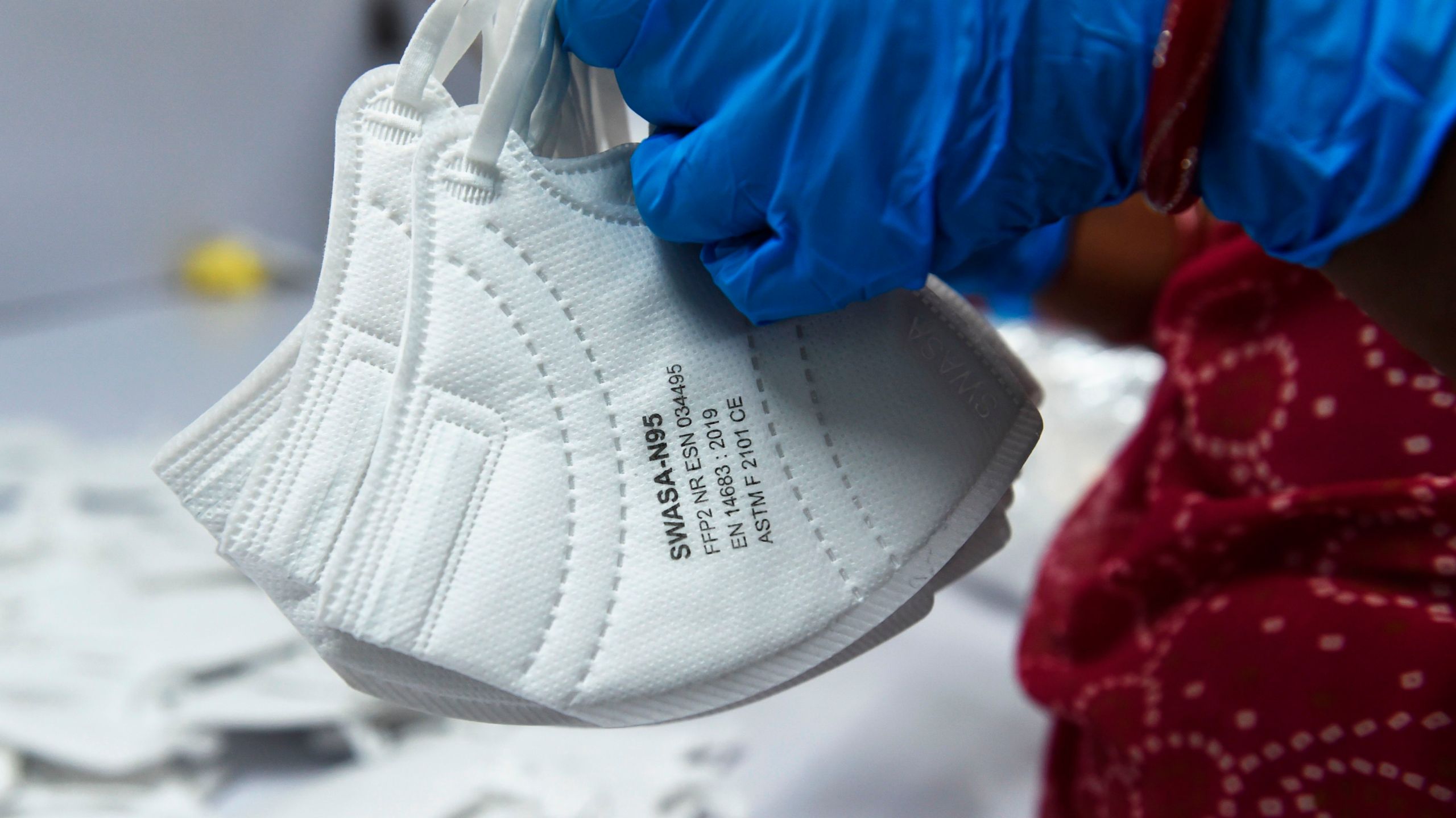 An employee wearing a face mask amid concerns of the spread of the COVID-19 coronavirus works at the production line of fac emasks at Salus Products, a manufacturer of surgical disposable products, on the outskirts of Ahmedabad, India, on March 12, 2020. (SAM PANTHAKY/AFP via Getty Images)