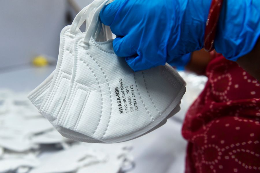 An employee wearing a face mask amid concerns of the spread of the COVID-19 coronavirus works at the production line of fac emasks at Salus Products, a manufacturer of surgical disposable products, on the outskirts of Ahmedabad, India, on March 12, 2020. (SAM PANTHAKY/AFP via Getty Images)