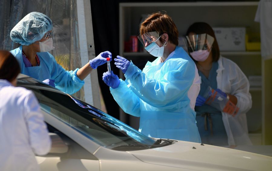 Medical workers at a Kaiser Permanente French Campus test a patient for the novel coronavirus, COVID-19, at a drive-thru testing facility in San Francisco on March 12, 2020. (JOSH EDELSON/AFP via Getty Images)