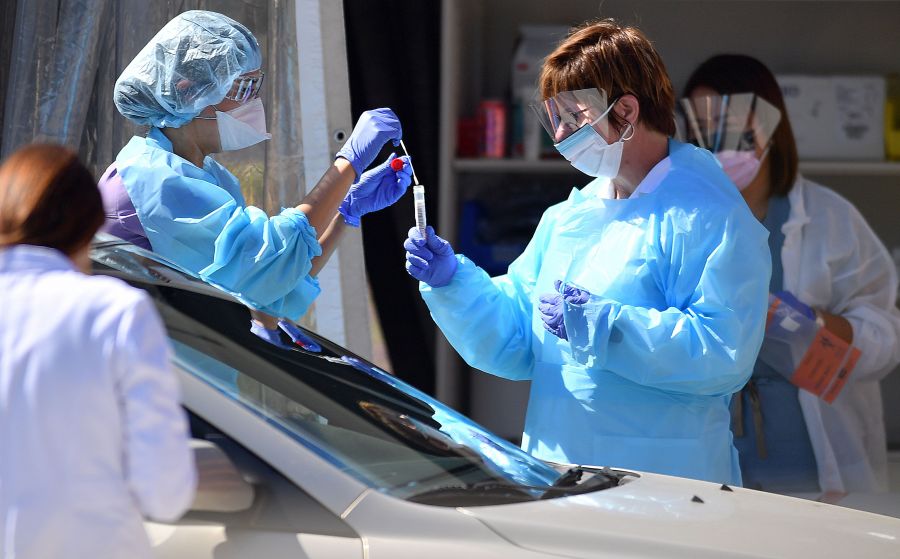 Medical workers at Kaiser Permanente French Campus test a patient for the novel coronavirus, COVID-19, at a drive-thru testing facility in San Francisco on March 12, 2020. (JOSH EDELSON/AFP via Getty Images)