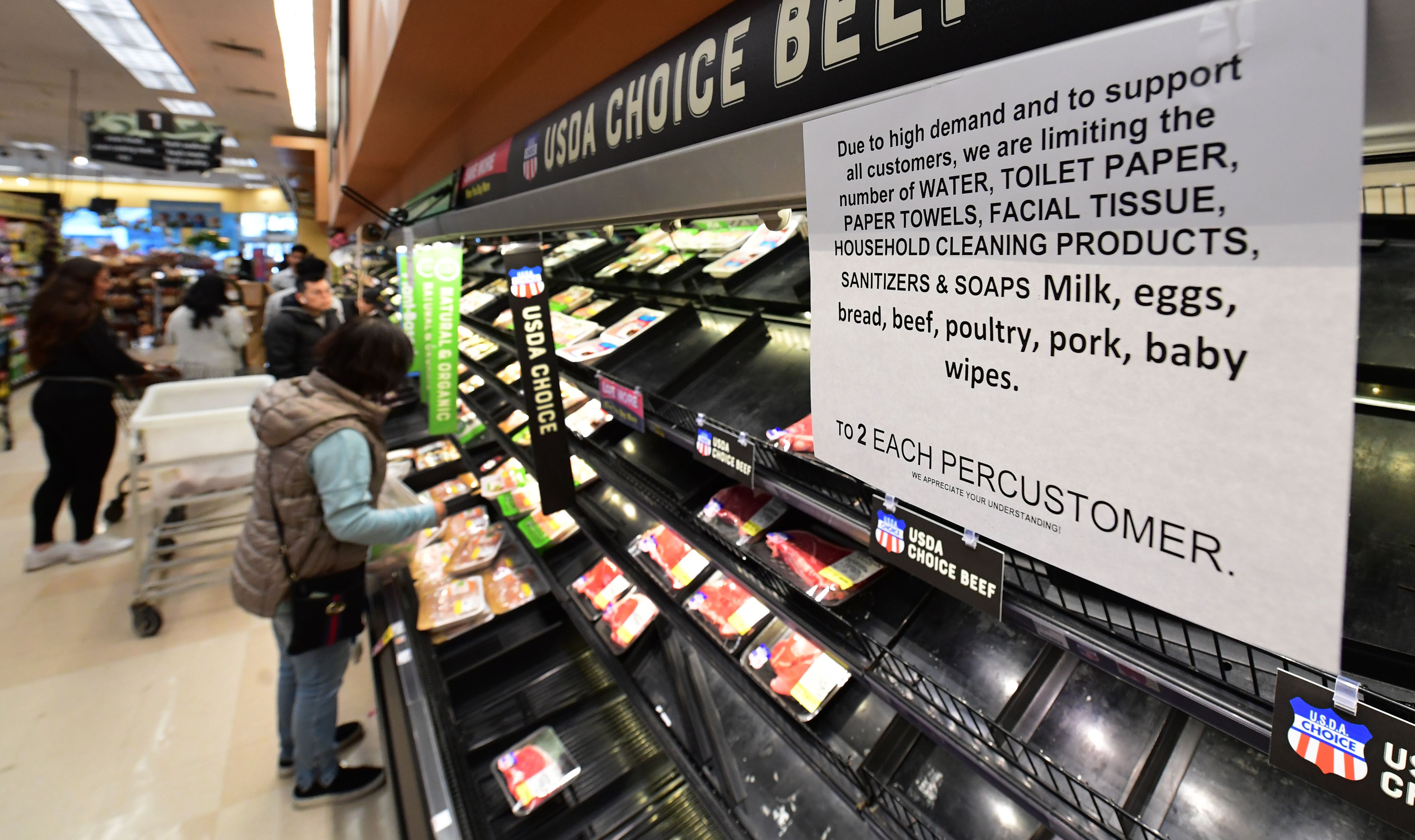 A sign announces a two-item limit for certain items as people shop for food at a Ralph's Supermarket in Monterey Park, Calif. on March 16, 2020, as the Coronavirus pandemic brings much of California to a standstill. (FREDERIC J. BROWN/AFP via Getty Images)