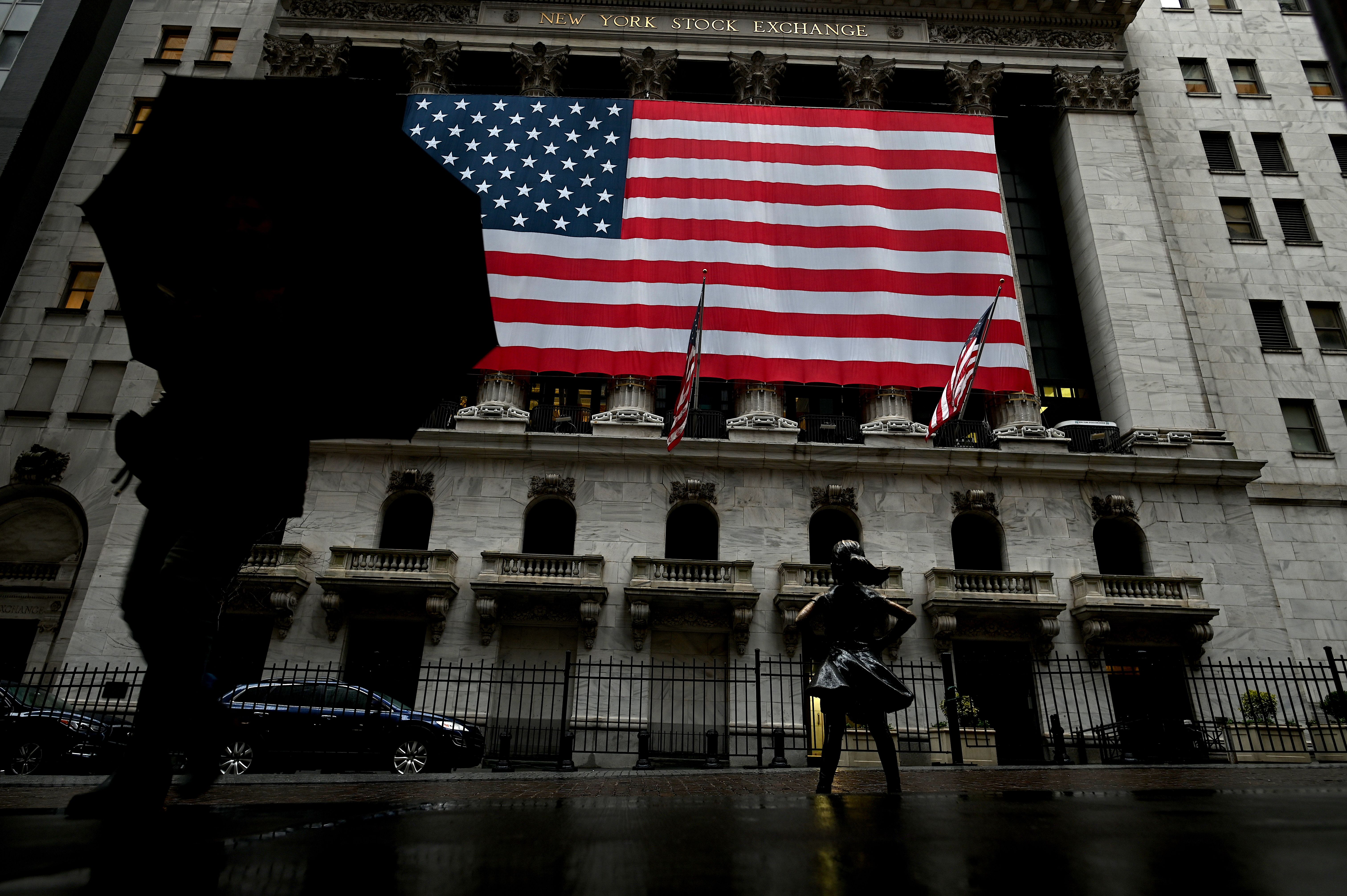 A woman walks past the New York Stock Exchange on March 19, 2020 at Wall Street in New York City. (JOHANNES EISELE/AFP via Getty Images)