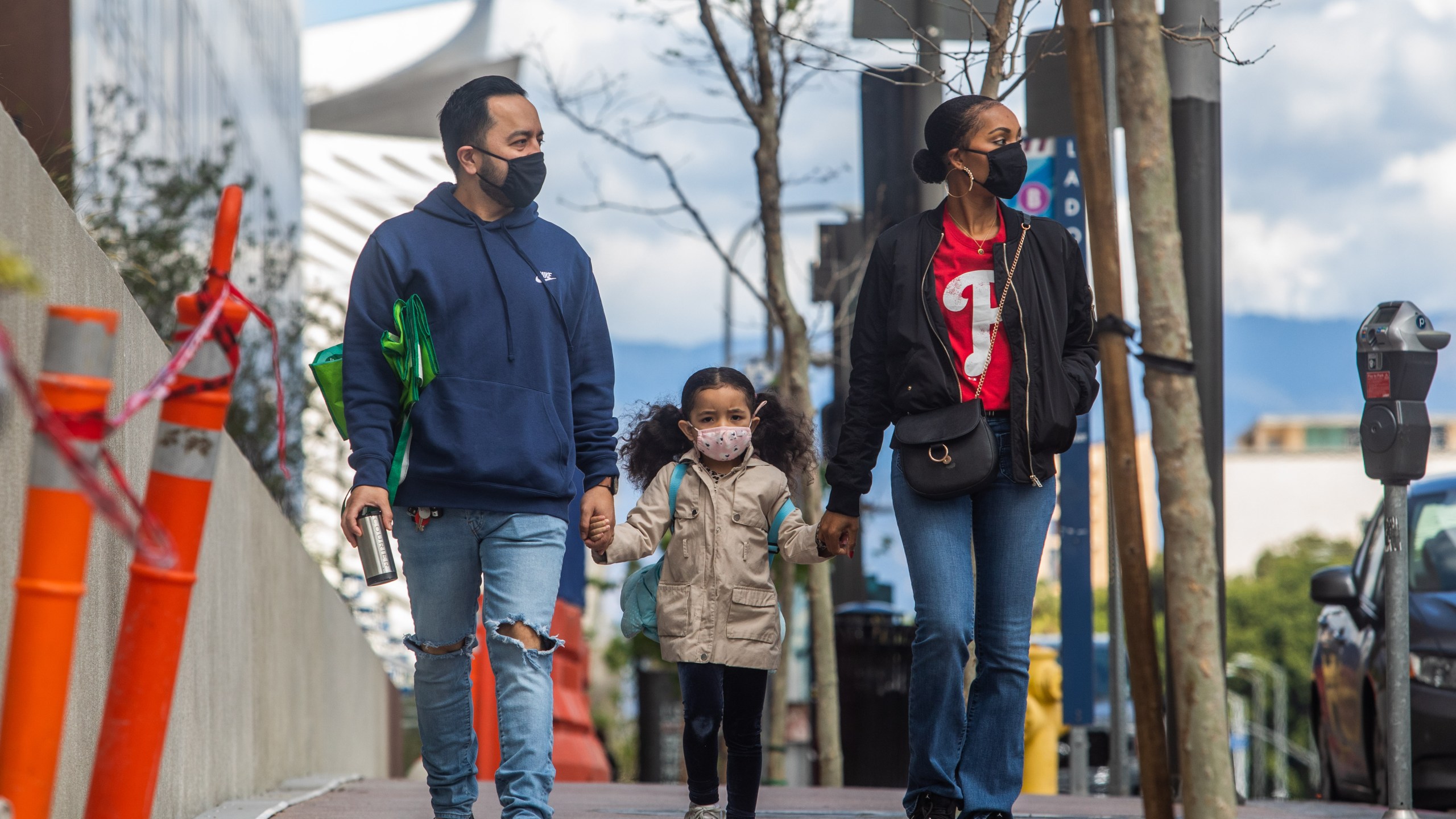 A family walks wearing masks in downtown Los Angeles on March 22, 2020, during the coronavirus outbreak. (APU GOMES/AFP via Getty Images)