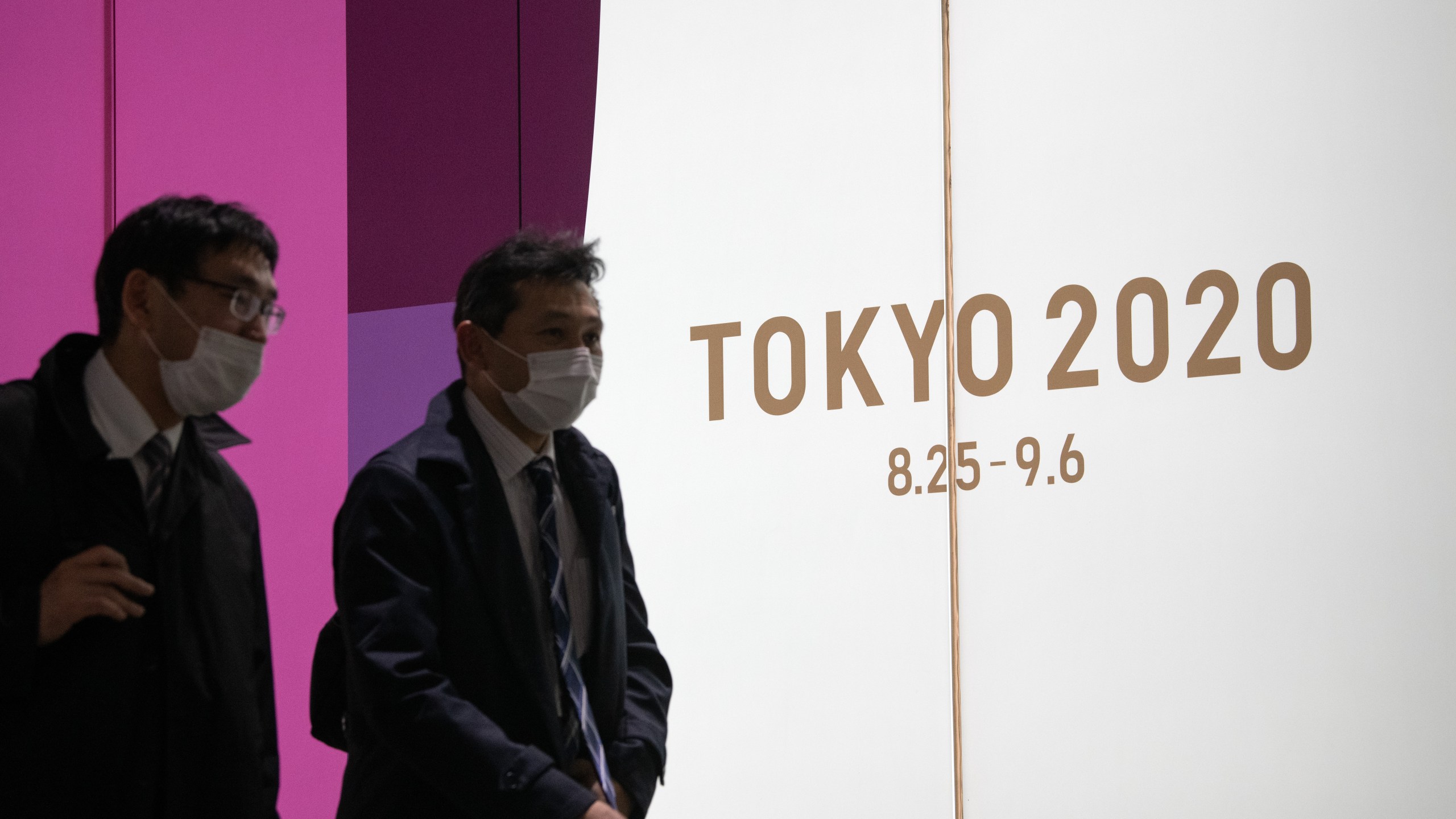 People pass an advert for the Tokyo 2020 Olympics on March 25, 2020 in Tokyo, Japan. (Carl Court/Getty Images)