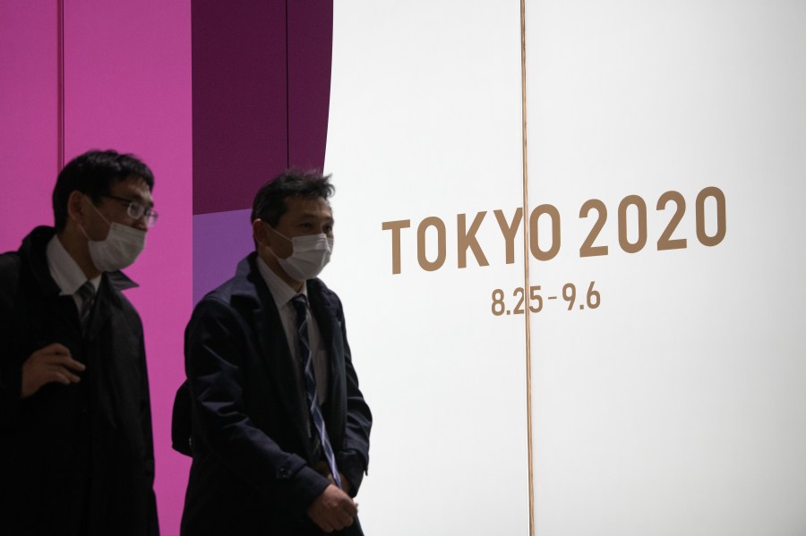 People pass an advert for the Tokyo 2020 Olympics on March 25, 2020 in Tokyo, Japan. (Carl Court/Getty Images)