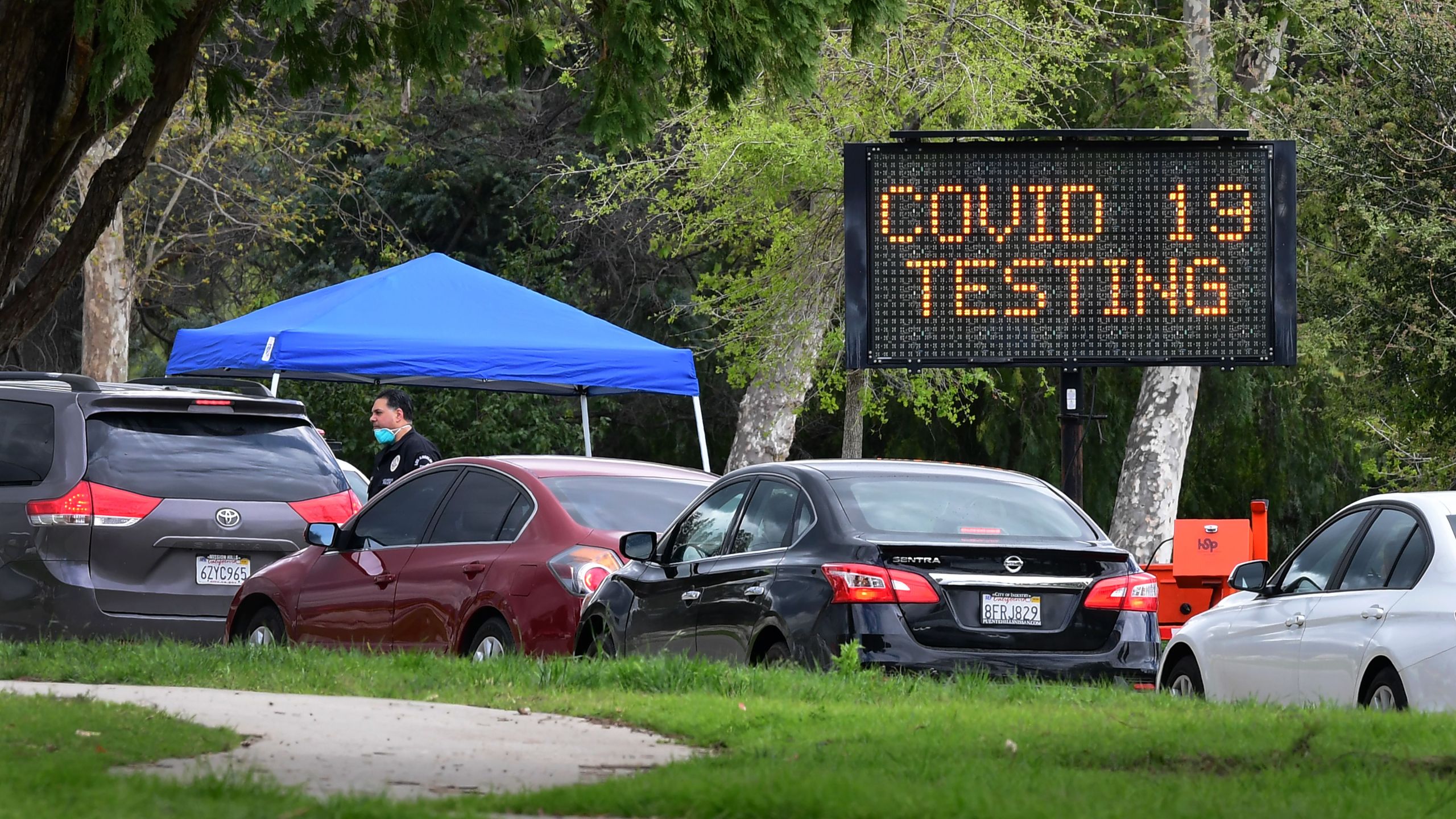 A police officer mans the entrance to a coronavirus testing center in Hansen Dam Park on March 25, 2020, in Pacoima, California. (FREDERIC J. BROWN/AFP via Getty Images)