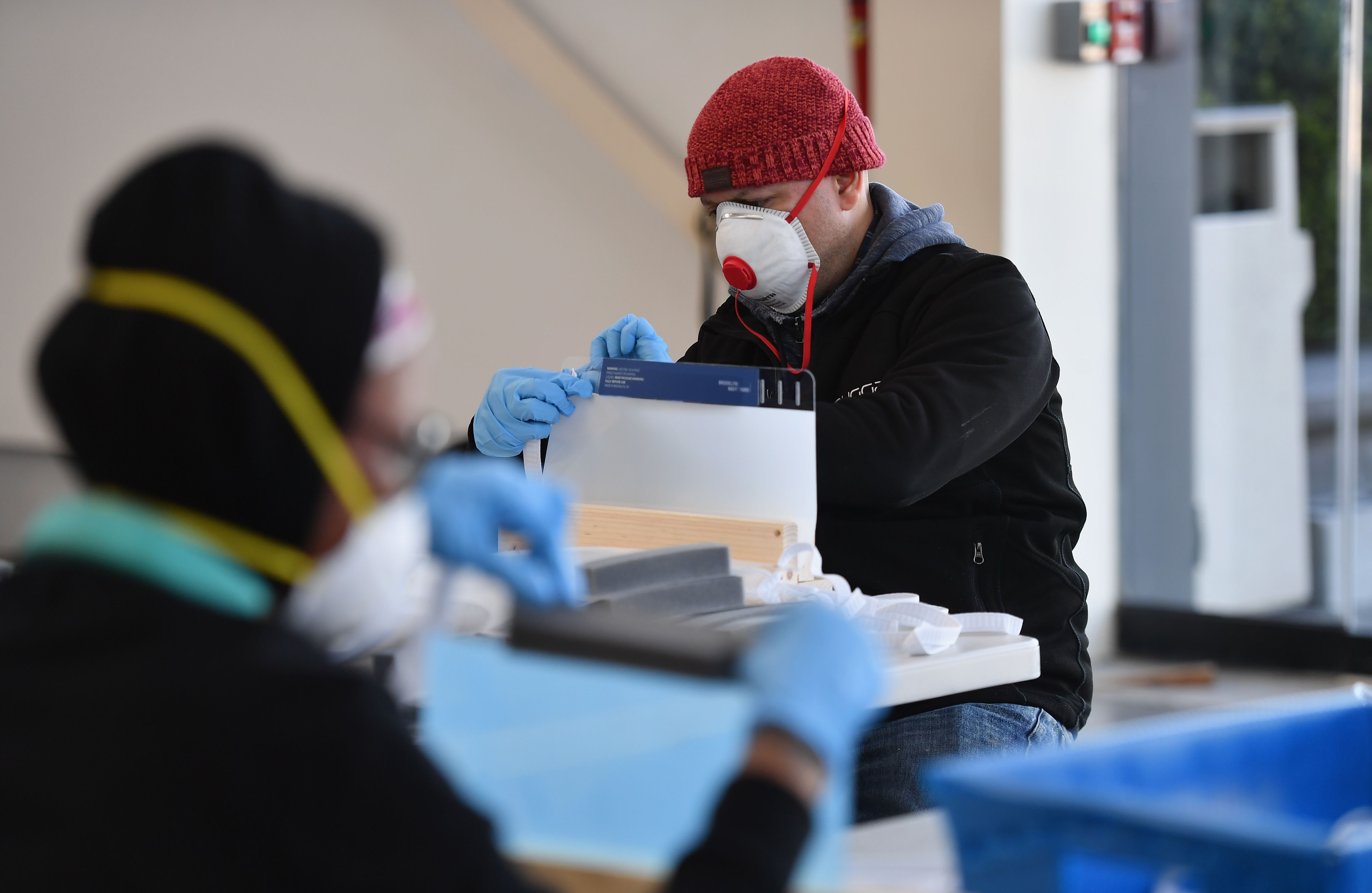 People work in the Brooklyn Navy Yard in New York City, where local industrial firms have begun manufacturing personal protective equipment like face shields, on March 26, 2020. (Credit: Angela Weiss / AFP / Getty Images)