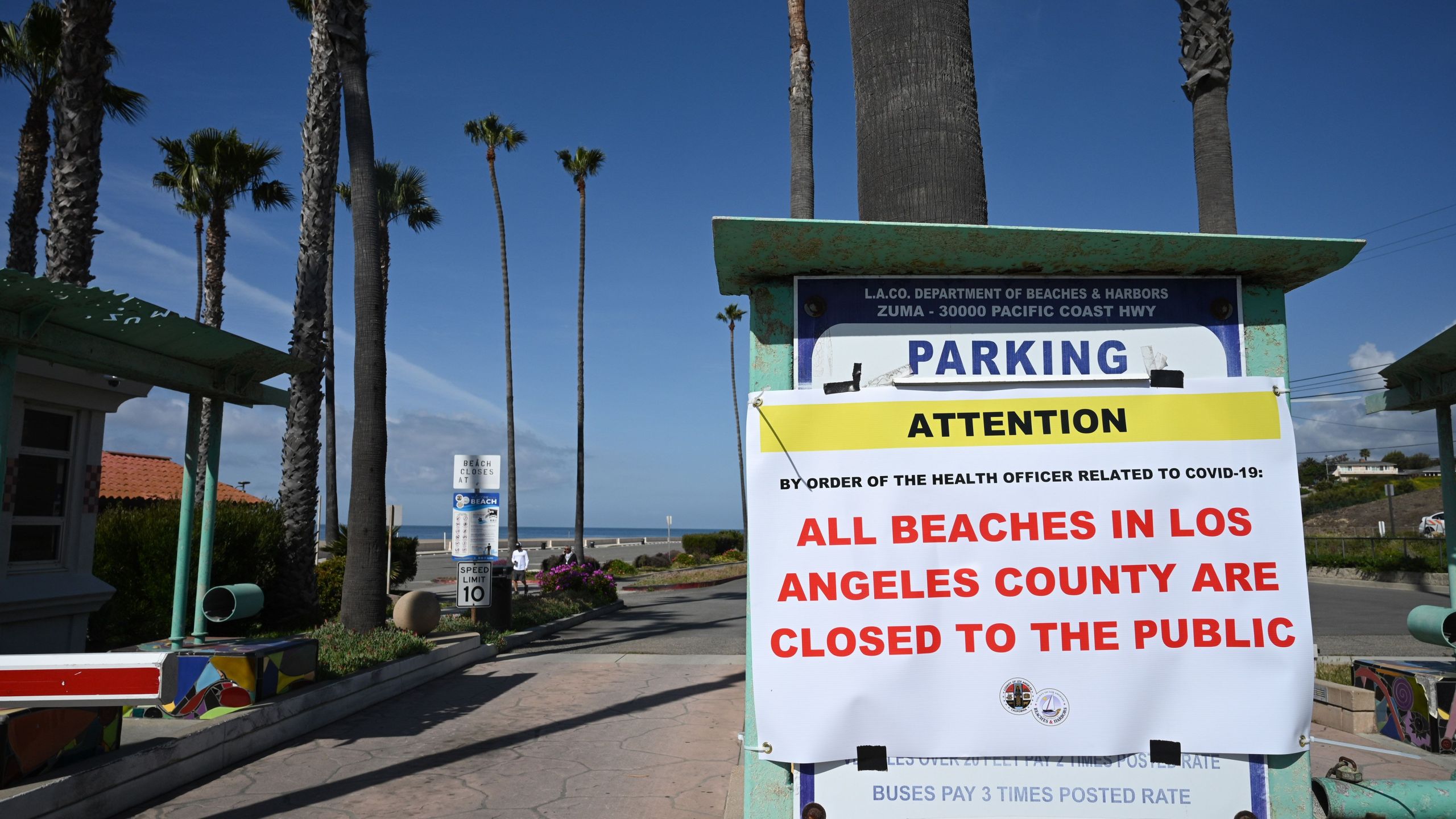 A sign reads that Zuma Beach in Malibu is closed to the public on March 28, 2020, in an effort to stem the growth of COVID-19 cases in Los Angeles County. (ROBYN BECK/AFP via Getty Images)